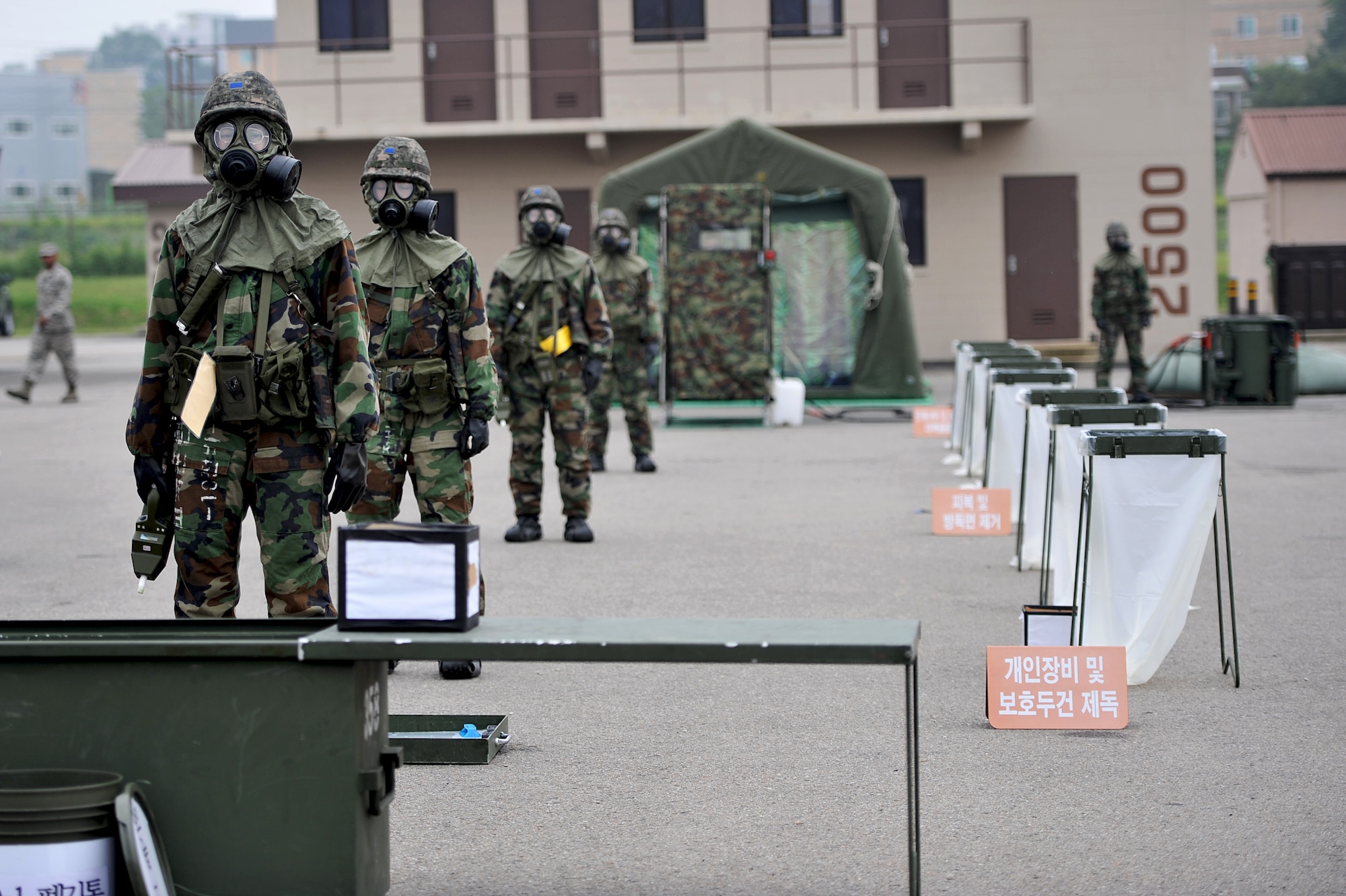 Republic of Korea air force emergency management readiness technicians standby to showcase how the ROKAF conducts contamination control area procedures during a joint chemical, biological, radiological, nuclear and explosives exercise at Osan Air Base, ROK, Sept. 12, 2013. Air Force and ROKAF CBRNE defense teams regularly train together to blend their operations and maintain a constant state of readiness.  (U.S.  Air Force photo/Staff Sgt. Emerson Nuñez)