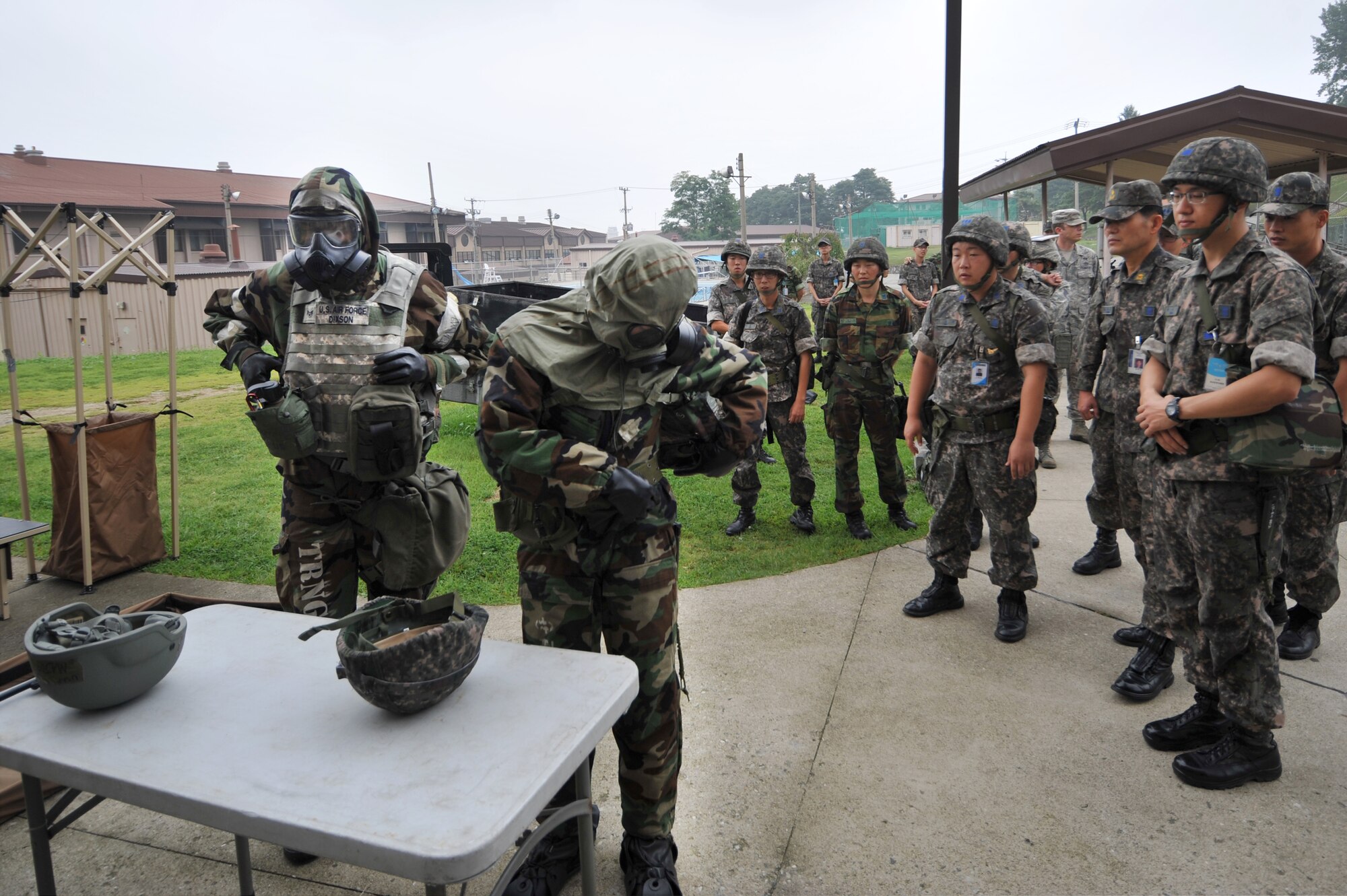Members of the Republic of Korea air force watch U.S. Air Force Senior Airman Major Dixon, 51st Civil Engineer Squadron emergency management readiness technician, and ROKAF Senior Airman Yong Hoon Jung conduct contamination control area procedures during a joint chemical, biological, radiological, nuclear and explosives exercise at Osan Air Base, ROK, Sept. 12, 2013. Joint training is conducted in order to improve working relationship between the two services. (U.S.  Air Force photo/Staff Sgt. Emerson Nuñez)