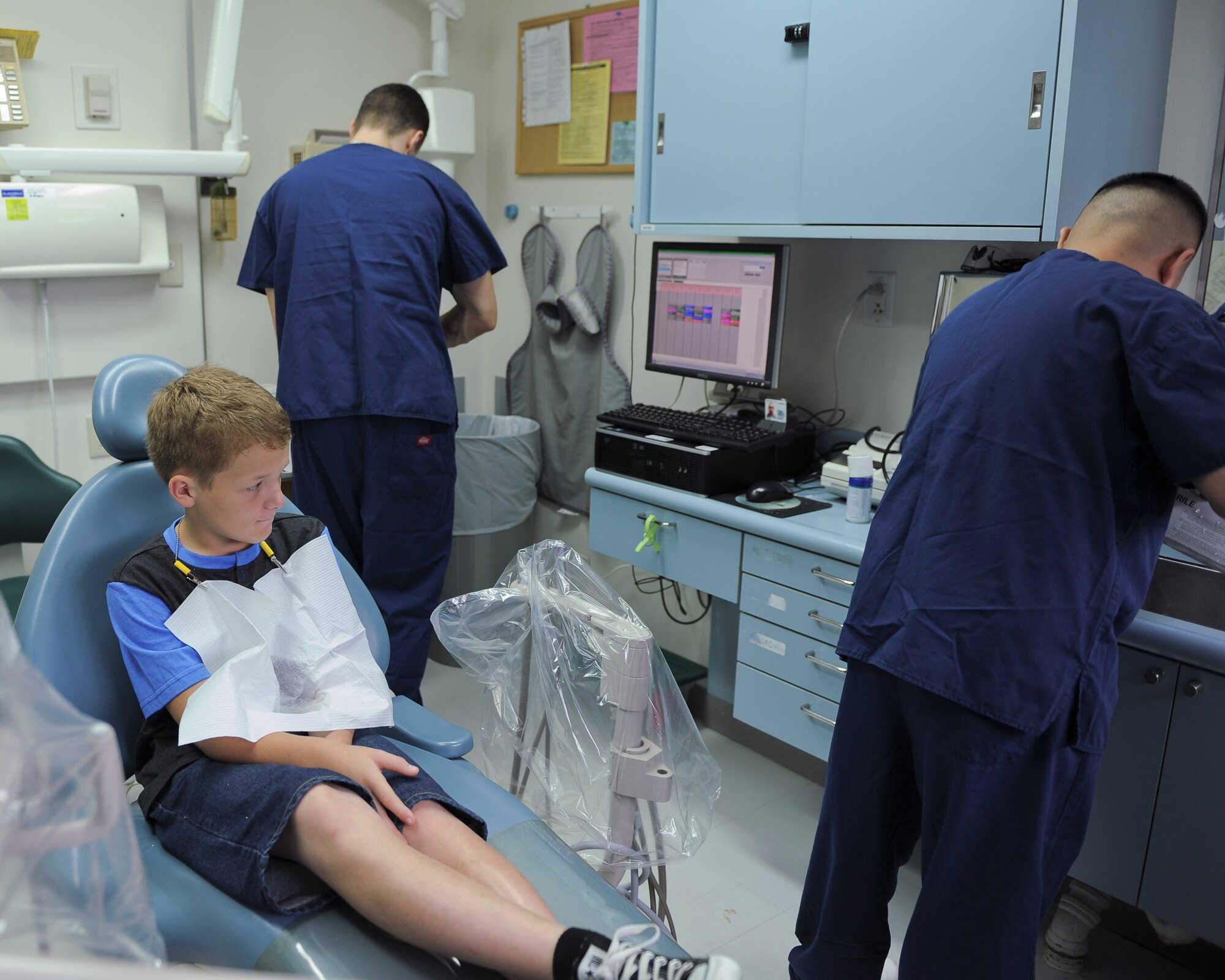 Cameron Cox, 12 years old, waits in a chair while dental assistants prepare a dental tray for a mouth impression at Yokota Air Base, Japan, Sept. 7, 2013. More than 35 patients had customized mouth guards made during a one-day clinic hosted by the 374th Dental Squadron. (U.S. Air Force photo by Senior Airman Desiree Economides/Released)