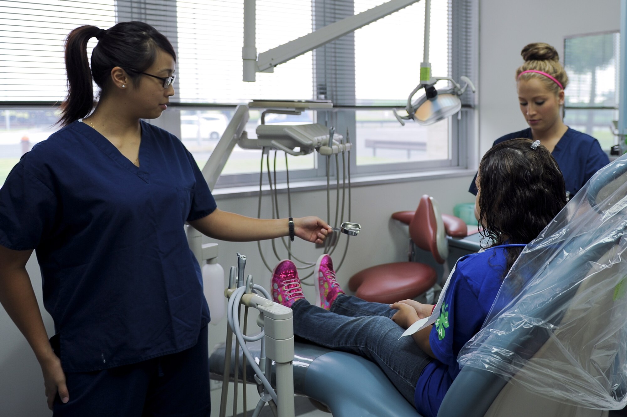 Senior Airman Jeanne Bryant, left, hands a dental tray to Senior Airman Christa Miller Sept. 7, 2013, at Yokota Air Base, Japan. The 374th Dental Squadron held a one-day mouth guard clinic to provide a convenient way for patients to have custom-made mouth guards made. Miller and Bryant are both dental assistants with the 374 DS. (U.S. Air Force photo by Senior Airman Desiree Economides/Released)