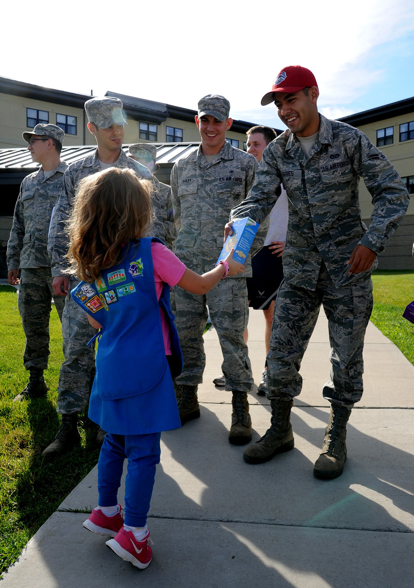 Airman 1st Class Daniel Torres, 819th RED HORSE Squadron structures journeyman, receives a box of Girl Scout cookies from a young scout. Scouts from troops 3030, 3218 and 3500 delivered more than 700 boxes of cookies to Malmstrom Air Force Base for use in each year’s holiday baskets for Airmen. (U.S. Air Force photo/Staff Sgt. R.J. Biermann)