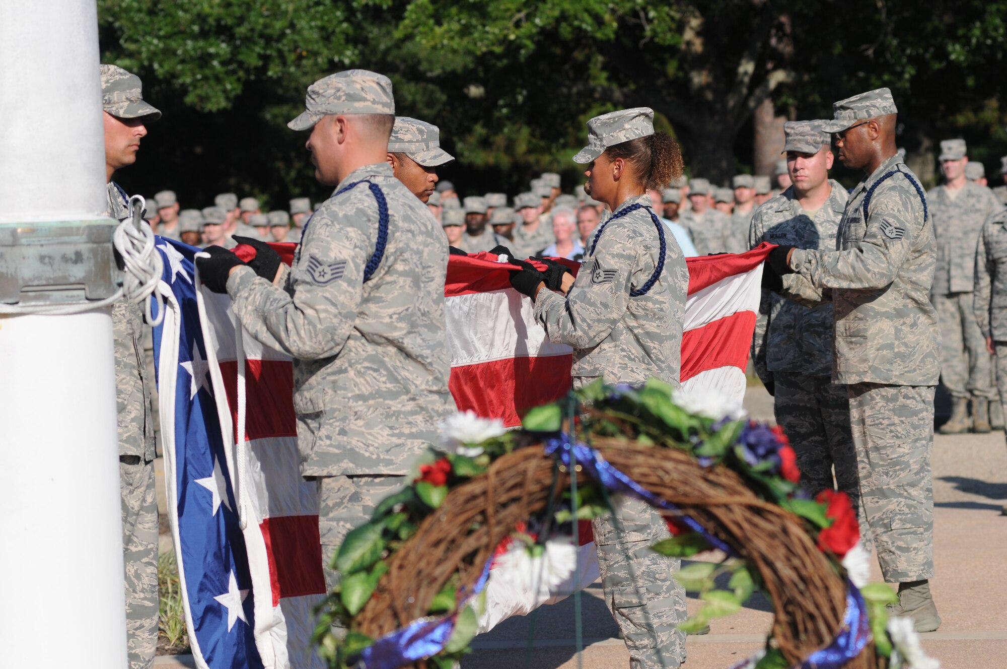Military training leaders fold the U.S. flag during a retreat ceremony Sept. 11, 2013, Keesler Air Force Base, Miss. The ceremony honored those who lost their lives during the 9/11 attacks.  (U.S. Air Force photo by Kemberly Groue)
