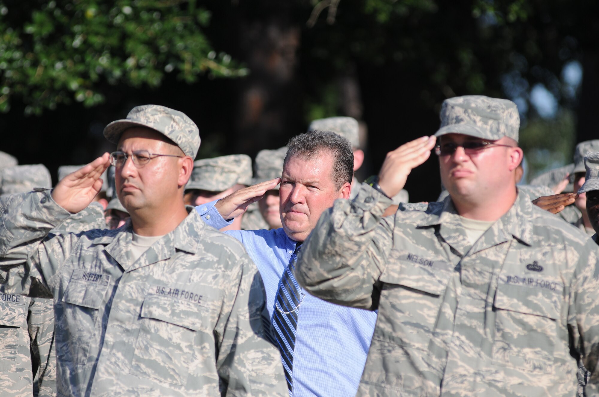 Mark Malone, 81st Mission Support Group, (center), and Master Sgts. John Hoefert, and Mark Nelson, 81st Communications Squadron, render a salute as taps is played during a retreat ceremony Sept. 11, 2013, Keesler Air Force Base, Miss. The ceremony honored those who lost their lives during the 9/11 attacks.  (U.S. Air Force photo by Kemberly Groue)