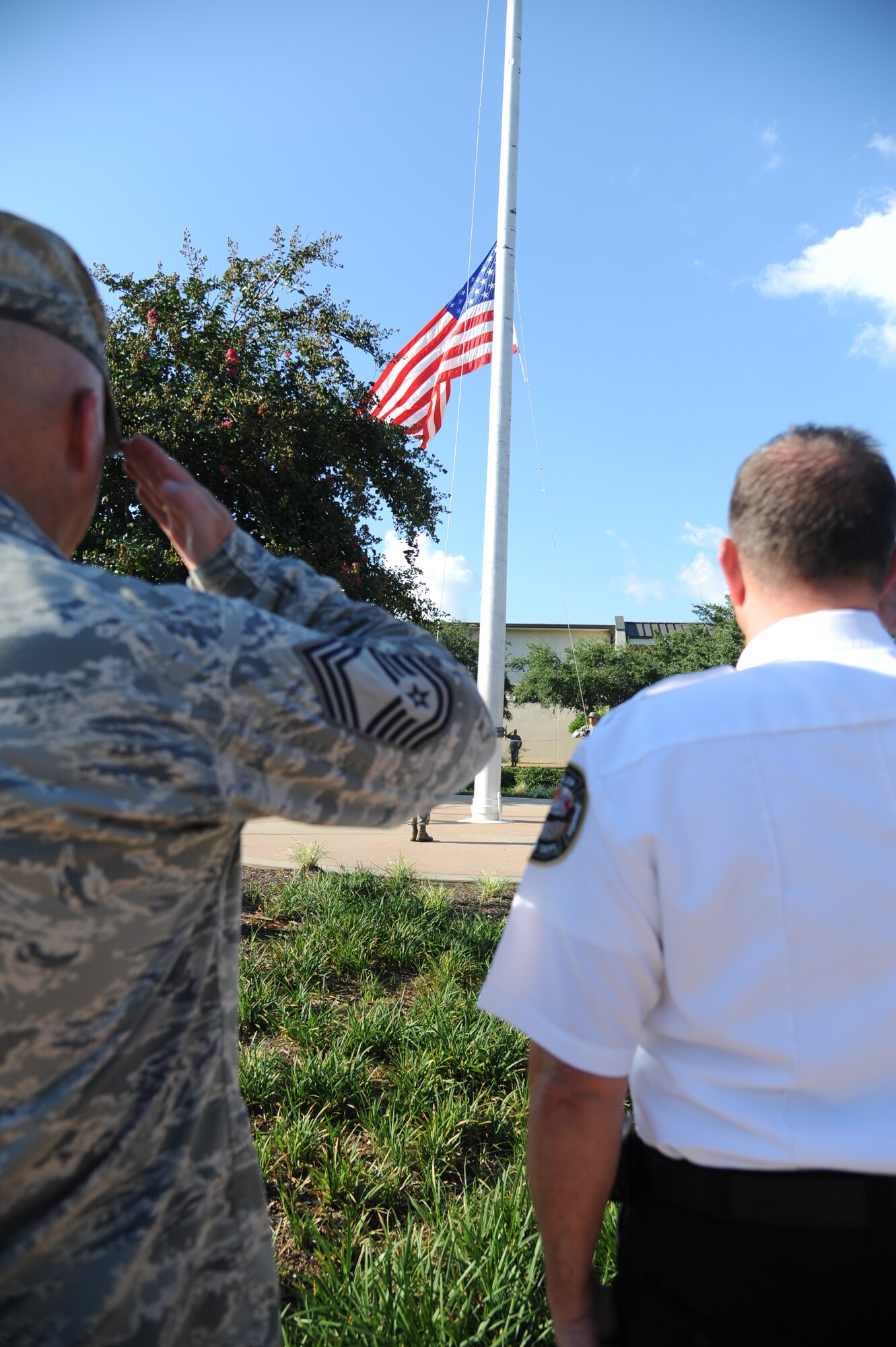Chief Master Sgt. Glen Usherwood, 81st Mission Support Group superintendant, and Chief James Donnett, Keesler Fire Department, render a salute as the U.S. flag is lowered during a retreat ceremony Sept. 11, 2013, Keesler Air Force Base, Miss. The ceremony honored those who lost their lives during the 9/11 attacks.  (U.S. Air Force photo by Kemberly Groue)