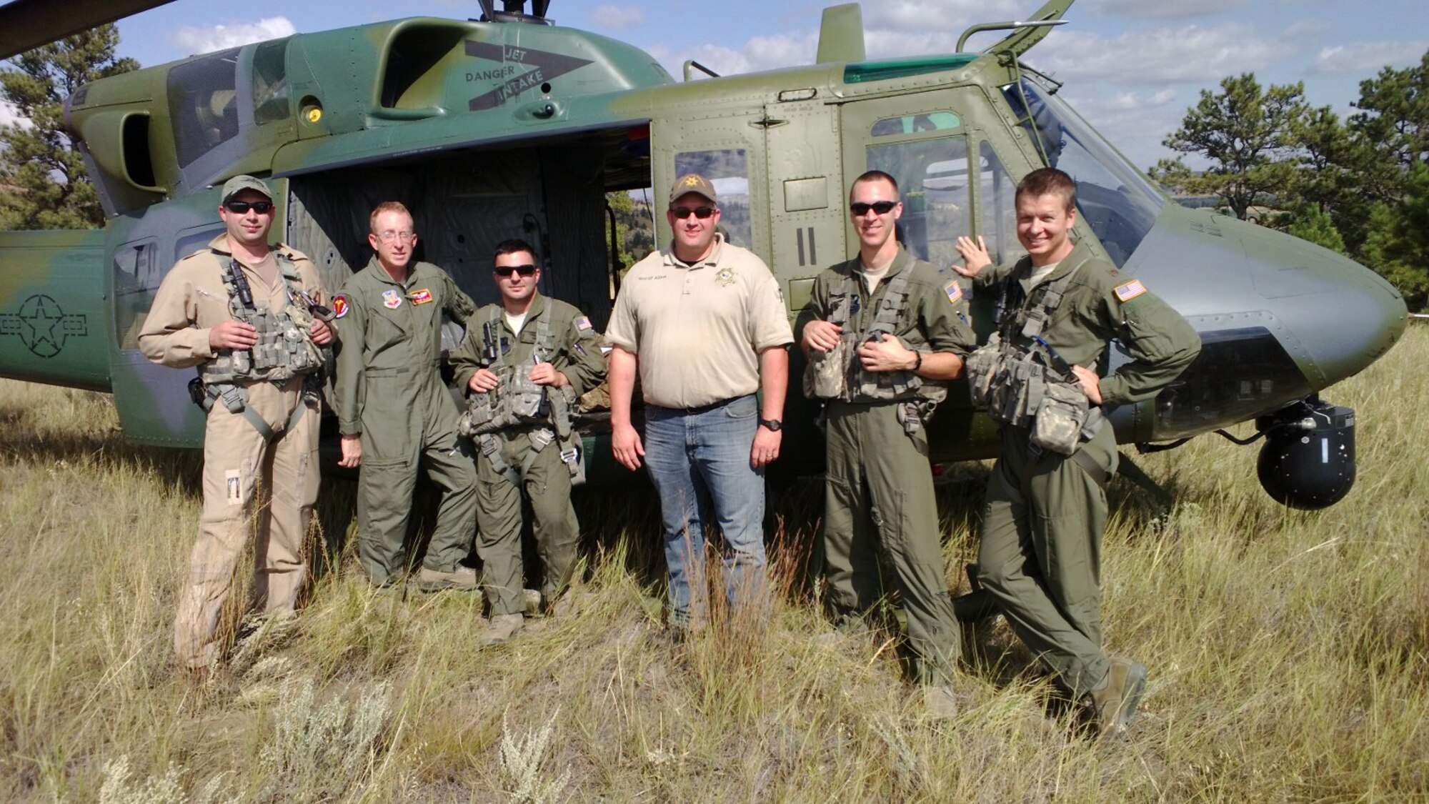 Members of the Rescue 11 aircrew pose for a photo with Sheriff Randy Allies. Aircrew from left to right are James Robbins,  40th Helicopter Squadron aircraft mechanic, Dr. (Maj.) Andrew Allen, Staff Sgt. Rob Sinyard, 37th Helicopter Squadron, F.E. Warren Air Force Base, Wyo.; and 40th HS members 1st Lt. RJ Bergman, and Maj. Kurt Ponsor. (Courtesy photo/Bill Dawson)