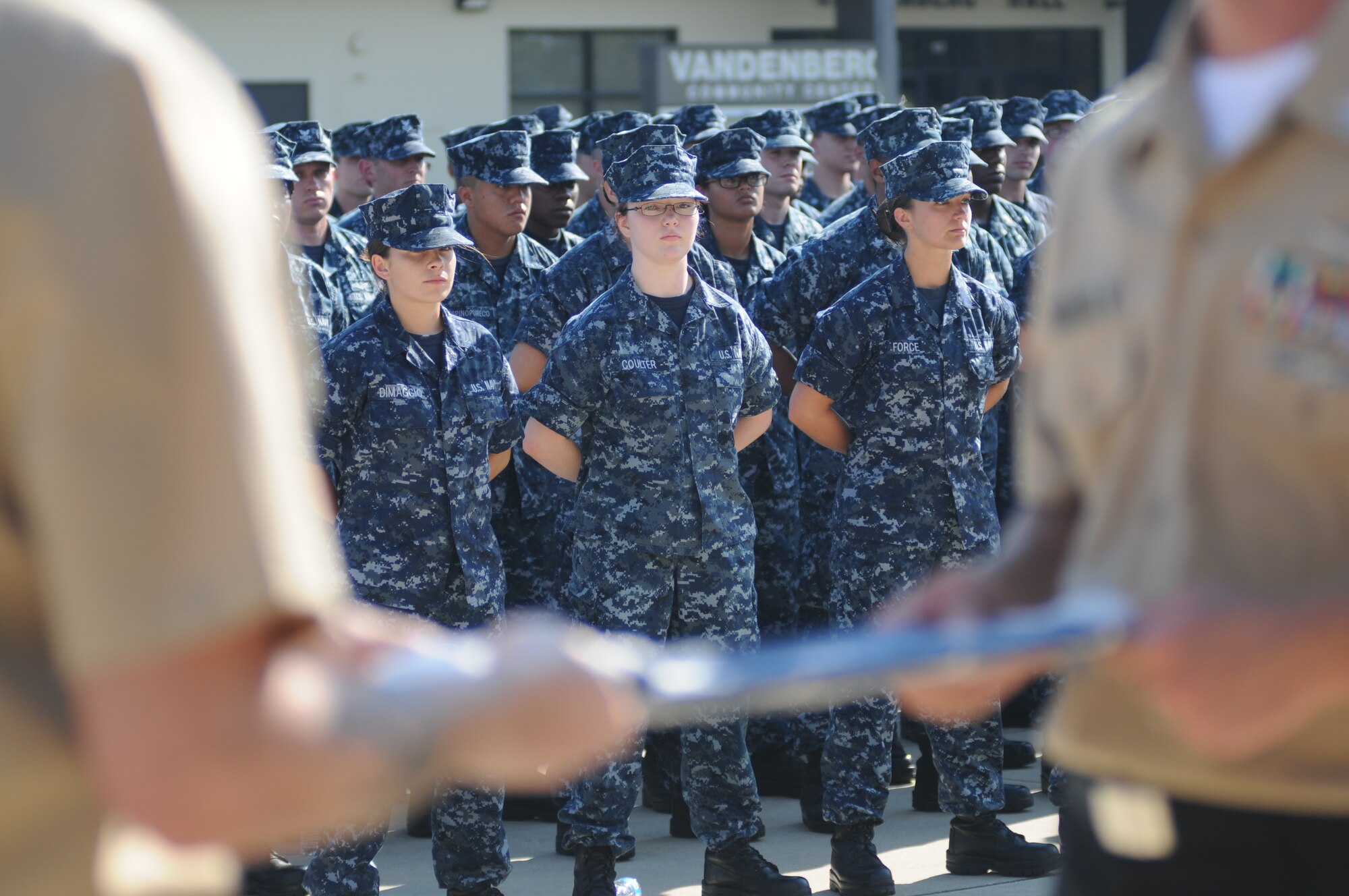 Members of The Center for Naval Aviation Technical Training Unit Keesler stand at parade rest as Petty Officers 1st Class Joel Seaney and Jason Bracken, CNATTU, unfold a worn U.S. flag to be retired during a Sept. 11, 2013, ceremony to honor those who have given their lives since 9/11, Keesler Air Force Base, Miss.  Also in attendance were members of the Keesler Marine Corps Detachment.  (U.S. Air Force photo by Kemberly Groue)