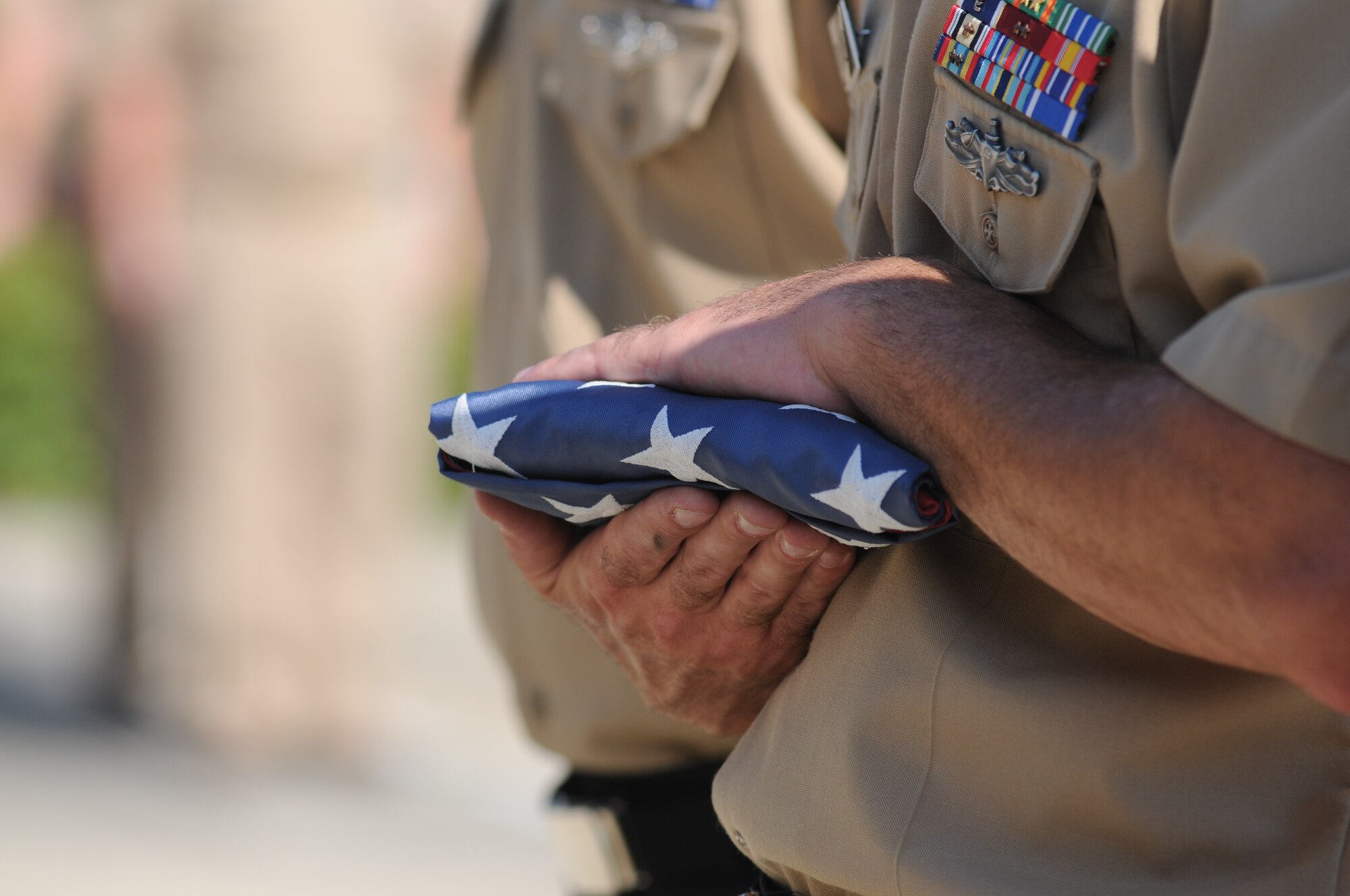Petty Officer 1st Class Jason Bracken, Center for Naval Aviation Technical Training Unit Keesler, holds a U.S. flag to be retired during a Sept. 11, 2013, ceremony to honor those who have given their lives since 9/11, Keesler Air Force Base, Miss.  Also in attendance were members of the Keesler Marine Corps Detachment.  (U.S. Air Force photo by Kemberly Groue)