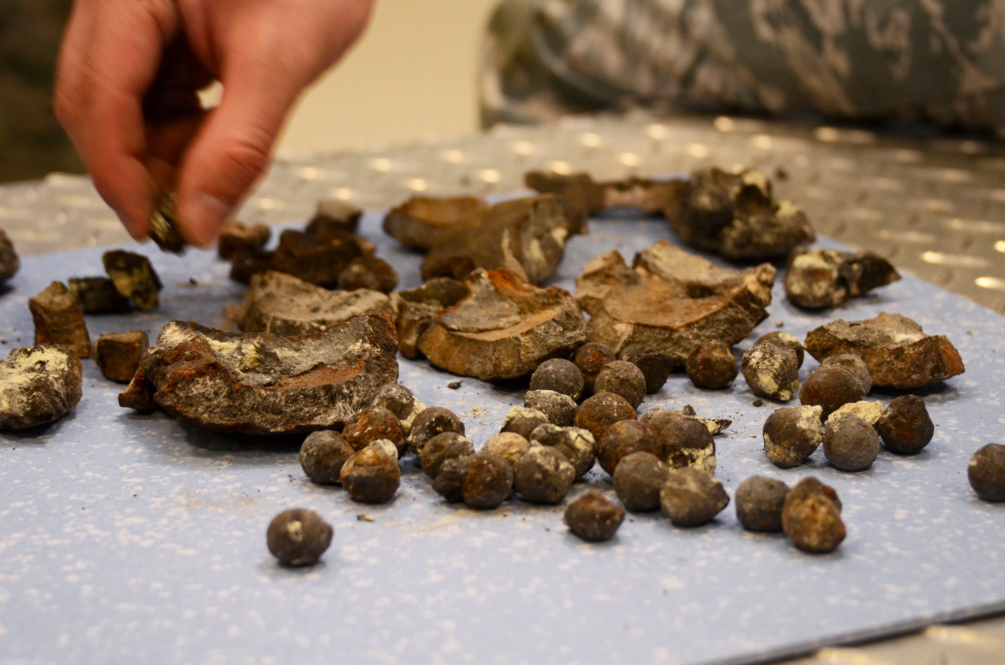 Members of the 94th Explosive Ordnance Flight examine fragments of a civil war era cannon ball Aug. 2. The cannon ball was detonated and disposed of by the Dobbins EOD team after being discovered near Centennial Park, downtown Atlanta July 18. (U.S. Air Force photo/Don Peek)