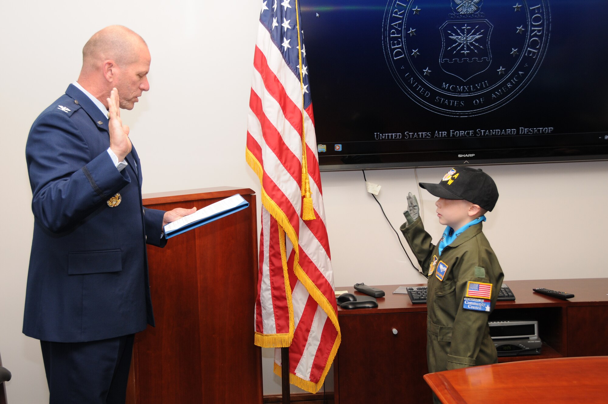 Air Force Reserve Col. David Post, commander of the 910th Maintenance Group, administers the oath of office swearing in nine-year-old Mason Burrows of Mineral Ridge, Ohio as an honorary second lieutenant here September 11, 2013. Mason was selected by Akron Children's Hospital Mahoning Valley to be honored as a pilot for a day. He is being treated for a rare blood disorder. Mason was taxied aboard a C-130 Hercules aircraft and given a special tour of the installation. The 910th Airlift Wing pilot for a day program began in 2000 to help bring a ray of sunshine into the lives of children being treated for chronic or life threatening conditions. U.S. Air Force photo by Tech. Sgt. Rick Lisum
