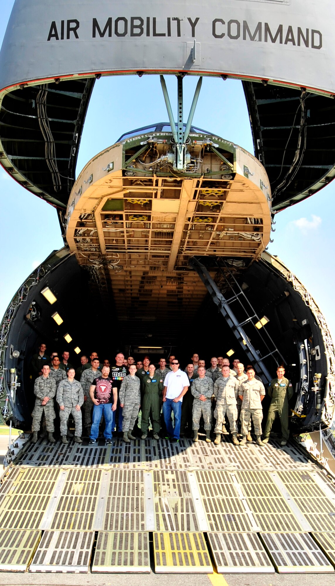 NASCAR Sprint Cup Series driver Kyle Busch poses for a group photo with Team Dover Airmen on the cargo ramp of a C-5M Super Galaxy during his visit Sept. 11, 2013 at Dover Air Force Base, Del. Busch attended the Sept. 11 Memorial dedication ceremony and spoke with and signed autographs for Airmen during his visit. (U.S. Air Force photo/Tech. Sgt. Chuck Walker)