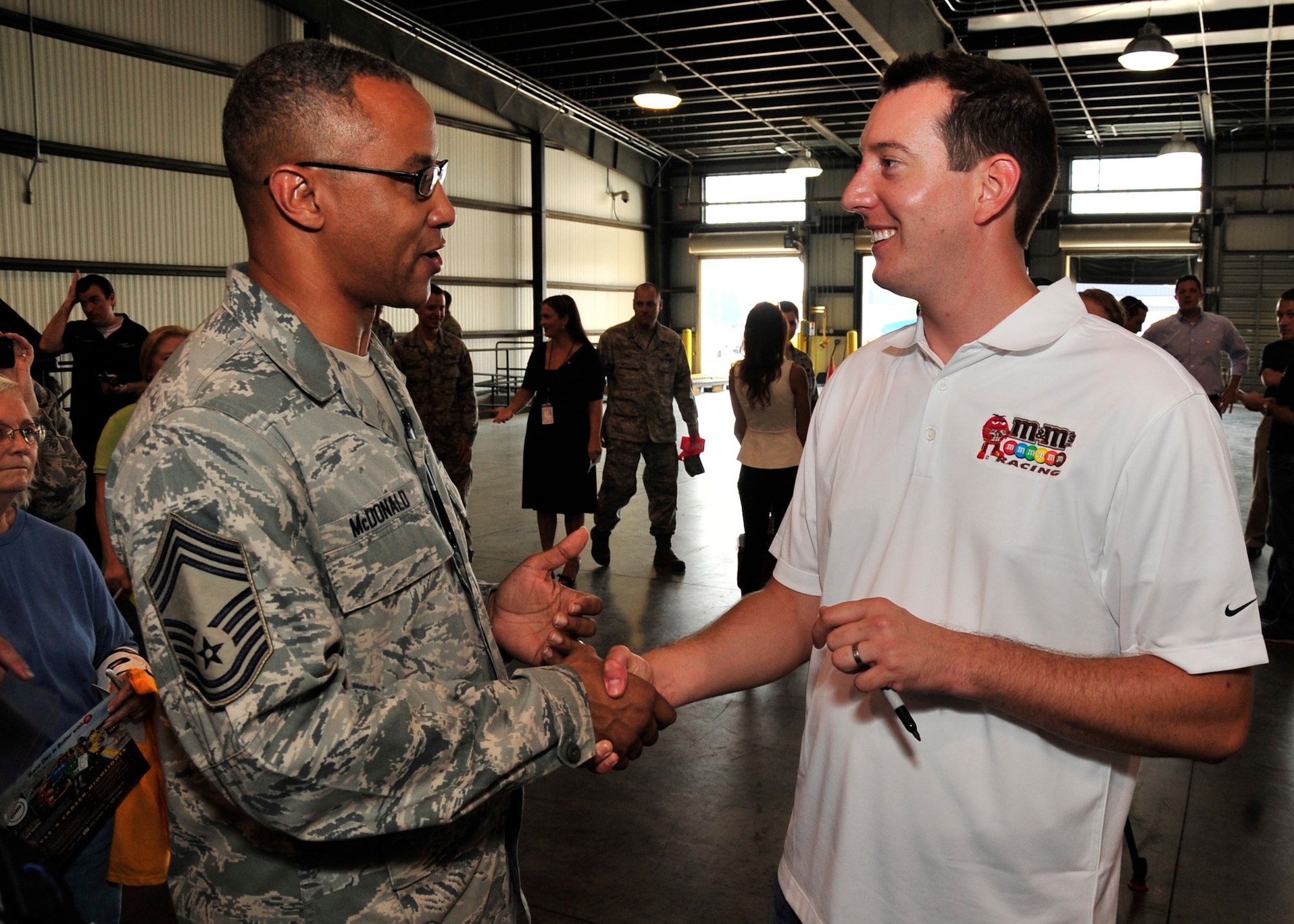 NASCAR Sprint Cup Series driver Kyle Busch receives a squadron coin from 
Chief Master Sgt. James Mcdonald, 436th Aerial Port Squadron chief enlisted manager, Sept. 11, 2013 at Dover Air Force Base, Del. Busch visited Dover AFB as part of NASCAR's Chase Across America tour. (U.S. Air Force photo/Staff Sgt. Elizabeth Morris)
