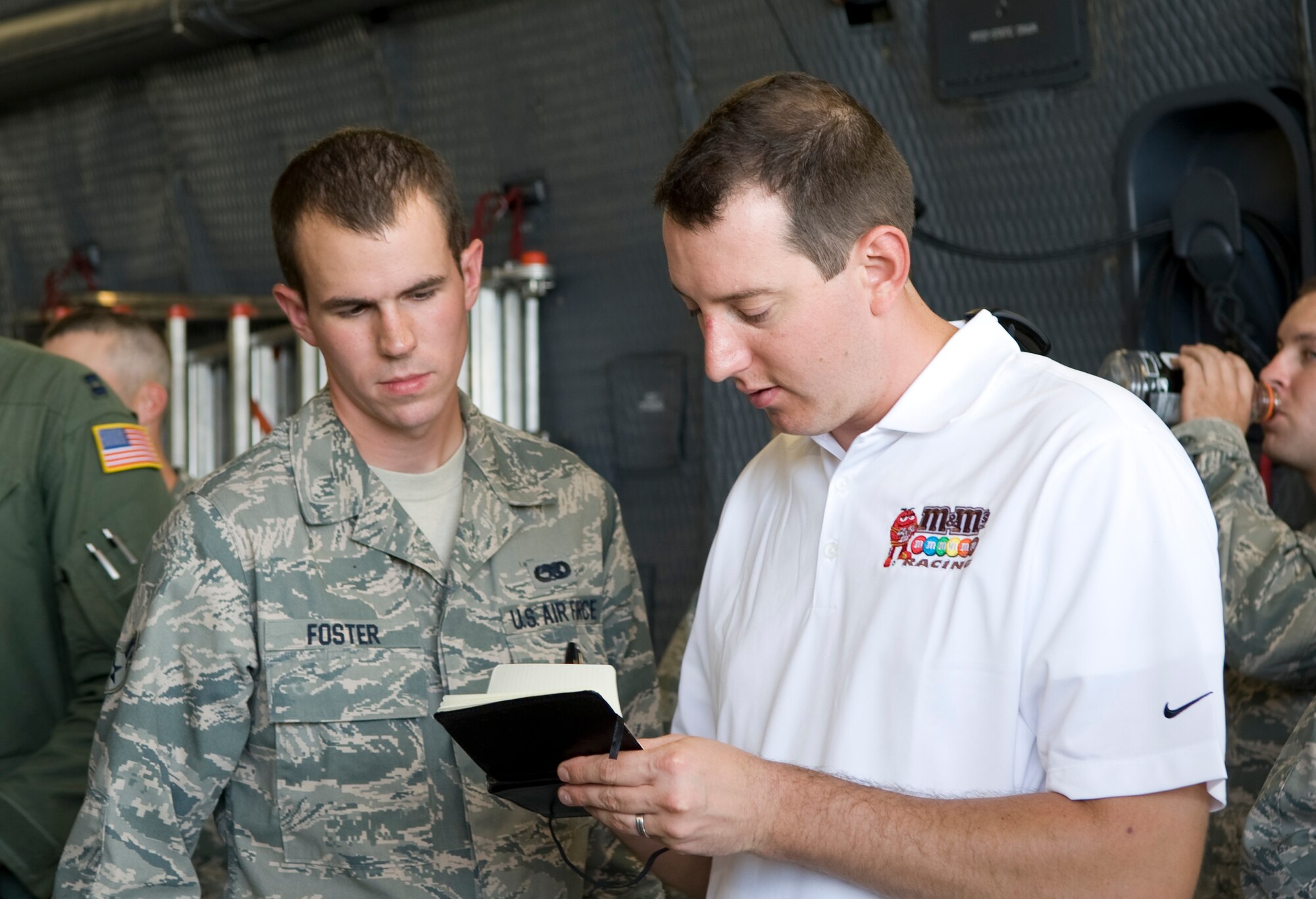 NASCAR Sprint Cup Series driver Kyle Busch signs an autograph for Airman 1st Class Jesse Foster, 436th Aircraft Maintenance Squadron aircraft maintainer, Sept. 11, 2013 at Dover Air Force Base, Del. Busch visited Dover AFB as part of NASCAR's Chase Across America tour. (U.S. Air Force photo/Staff Sgt. Elizabeth Morris)


