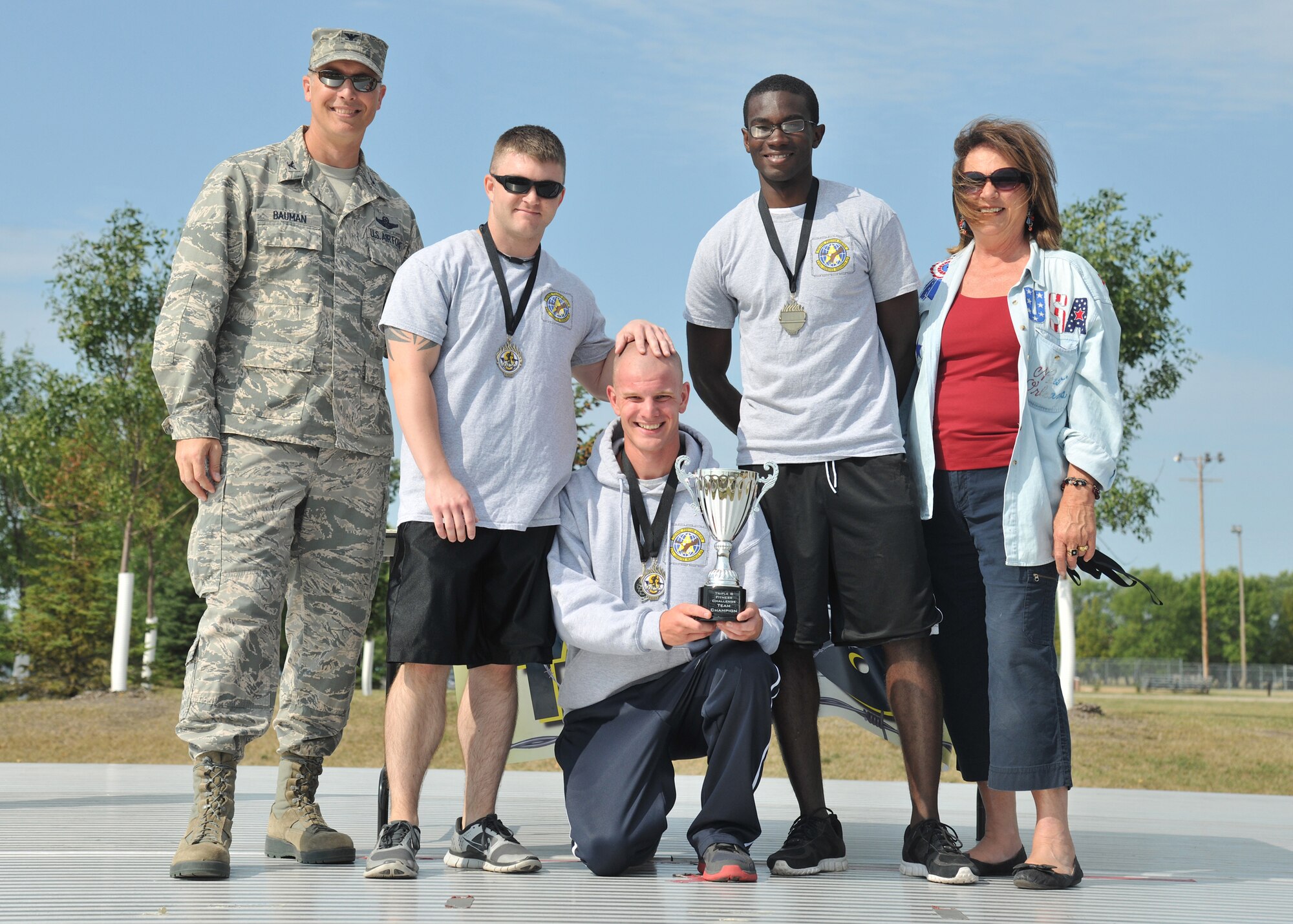Col. Paul Bauman, 319th Air Base Wing commander, poses with members of the 319th Logistics Readiness Squadron team who placed first with 89 points during the Triple 8 Fitness Challenge at the base outdoor running track on Grand Forks Air Force Base, N.D., on Sept. 5, 2013. The Triple 8 Fitness Challenge is a premier fitness event designed to test the conditioning limits of Air Force athletes and to distinguish an elite group that sets the fitness standard. (U.S. Air Force photo/Senior Airman Xavier Navarro)