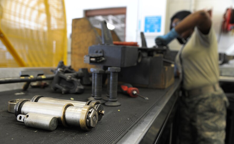Senior Airman Dominique Dowell, 2nd Munitions Squadron armament flight technician, inspects a MAU-12 ejector rack on Barksdale Air Force Base, La., Sept. 11, 2013. Dowell removed the ejector pistons to clean around the parts and the area where it attaches to the MAU-12. The ejector piston pushes the bomb away from the grasp of the MAU-12. (U.S. Air Force photo/Senior Airman Joseph A. Pagán Jr.)