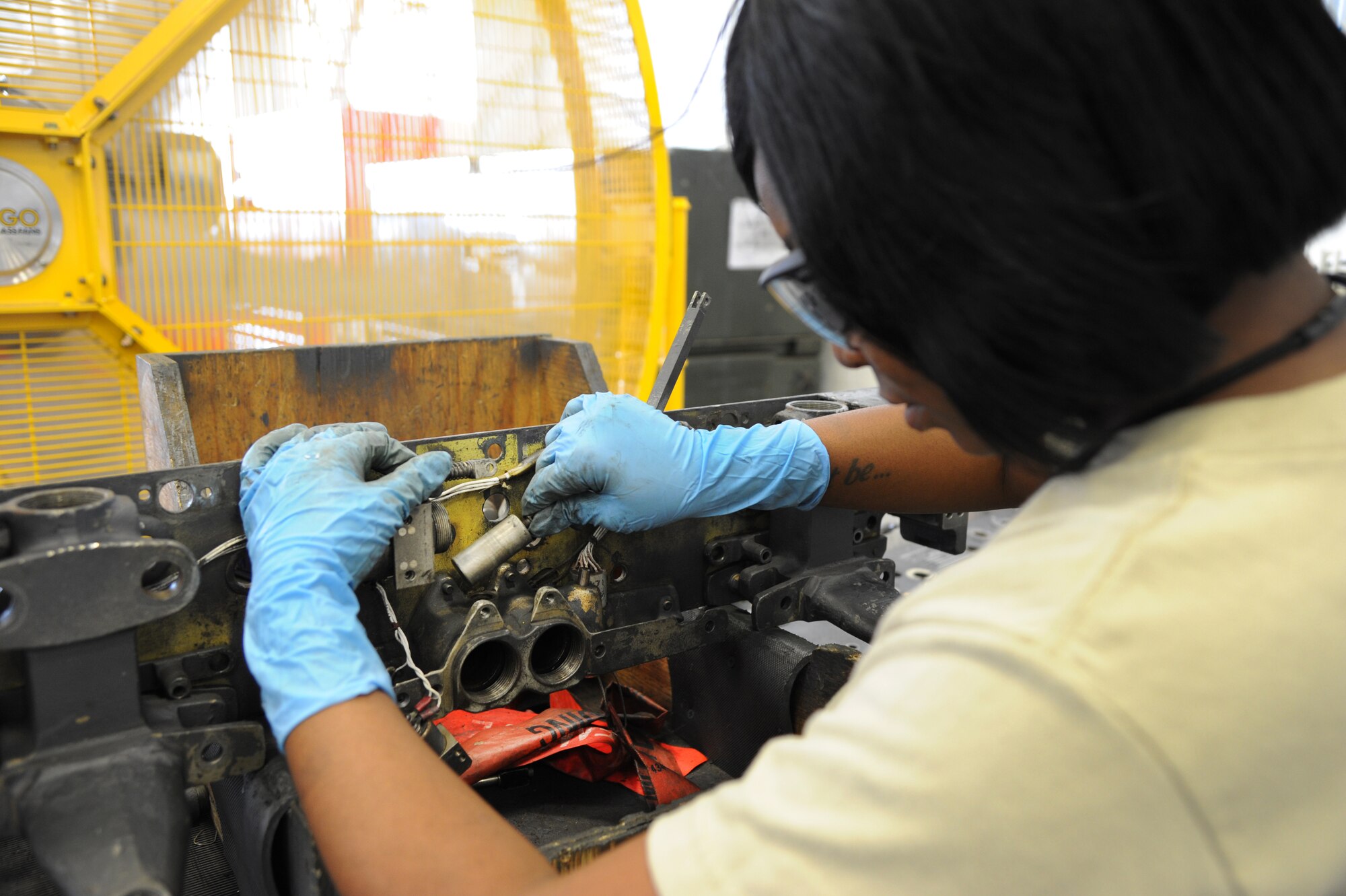 Senior Airman Dominique Dowell, 2nd Munitions Squadron armament flight technician, removes an in-flight lockout solenoid plunger from a MAU-12 ejector rack on Barksdale Air Force Base, La., Sept. 11, 2013. Dowell was performing an inspection on the MAU-12 to ensure it continues working properly. Together, the plunger and solenoid release a bomb from the grasp of a MAU-12 when engaged. (U.S. Air Force photo/Senior Airman Joseph A. Pagán Jr.)