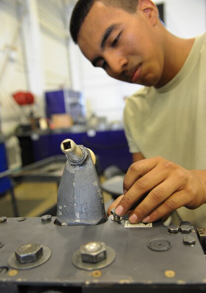 Airman 1st Class Manuel Figueroa, 2nd Munitions Squadron armament flight technician, tightens a bolt down on the left hand side plate of a MAU-12 ejector rack on Barksdale Air Force Base, La., Sept. 11, 2013. A MAU-12 is designed to suspend from a pylon attached to a B-52H Stratofortress. (U.S. Air Force photo/Senior Airman Joseph A. Pagán Jr.)