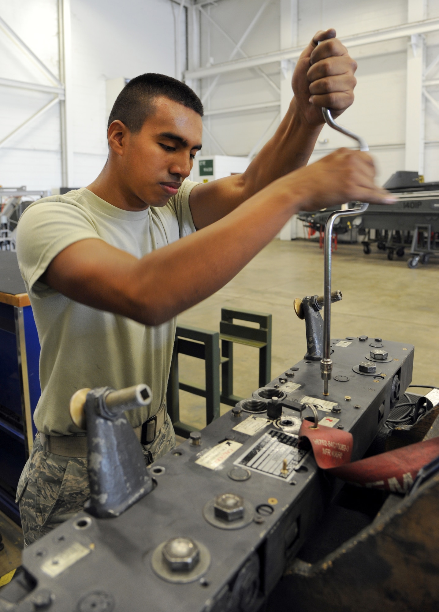 Airman 1st Class Manuel Figueroa, 2nd Munitions Squadron armament flight technician, uses a speed handle to tighten a screw on the left hand side plate of a MAU-12 ejector rack on Barksdale Air Force Base, La., Sept. 11, 2013. Figueroa took apart and repaired the MAU-12 after it failed a routine inspection. (U.S. Air Force photo/Senior Airman Joseph A. Pagán Jr.)