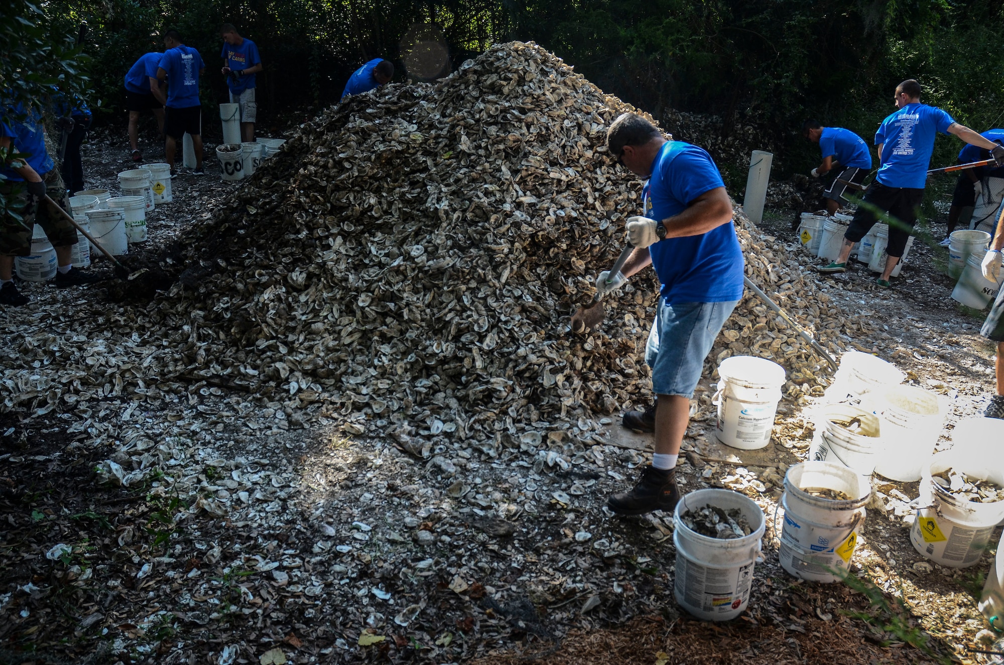 Ray Sagan , 437th Maintenance Squadron Aerospace Ground Equipment technician, shovels recycled oyster shells into a bucket, Sept. 6, 2013, at the Fort Johnson Oyster Reef Center in Charleston, S.C. The South Carolina Oyster Resoration and Enhancement program uses the oyster shells to fill bags to create new oyster habitats in the local waters which in turn, improves water quality. Approximately 2,500 service members from JB Charleston participated in the Trident United Way’s Day of Caring, volunteering their skills to assist with more than 50 projects in the local community.  (U.S. Air Force Photo/ 2nd Lt. Alexandra Trobe)