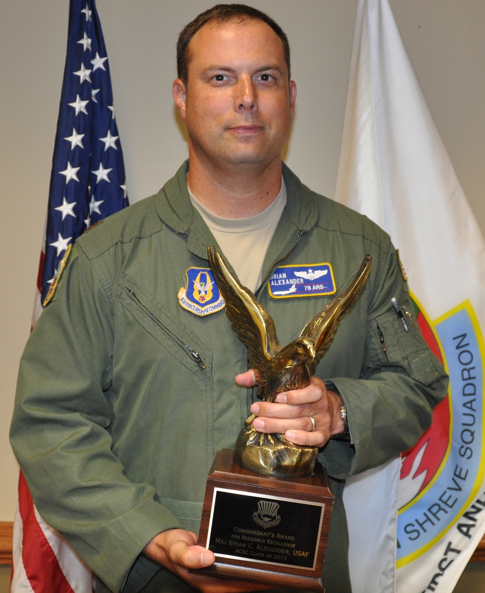 Maj. Brian Alexander, 78th Air Refueling Squadron KC-10 Extender pilot, displays his Airlift Tanker Association Global Reach award for excellence in research given by Air Command and Staff College Aug. 25, 2013, at Joint Base McGuire-Dix-Lakehurst, N.J. Alexander topped more than 900 students to win the top honor while completing his master’s degree in military operational art and science (U.S. Air Force photo by Senior Airman Chelsea Smith/Released)