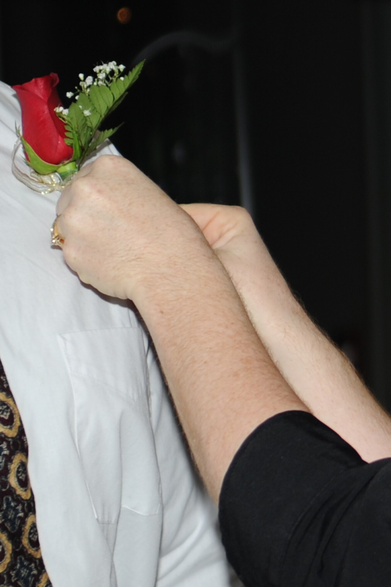 GOODFELLOW AIR FORCE BASE, Texas -- Tech. Sgt. Lisa Cacao, 17th Training Wing chaplains’ assistant, pins a corsage onto the shirt of a participant during the MarriageCare Retreat black tie dinner at the Event Center Sept. 7. The retreat provided couples time to focus on each other, renewing and revitalizing their marriage. (U.S. Air Force photo by Staff Sgt. Laura R. McFarlane)