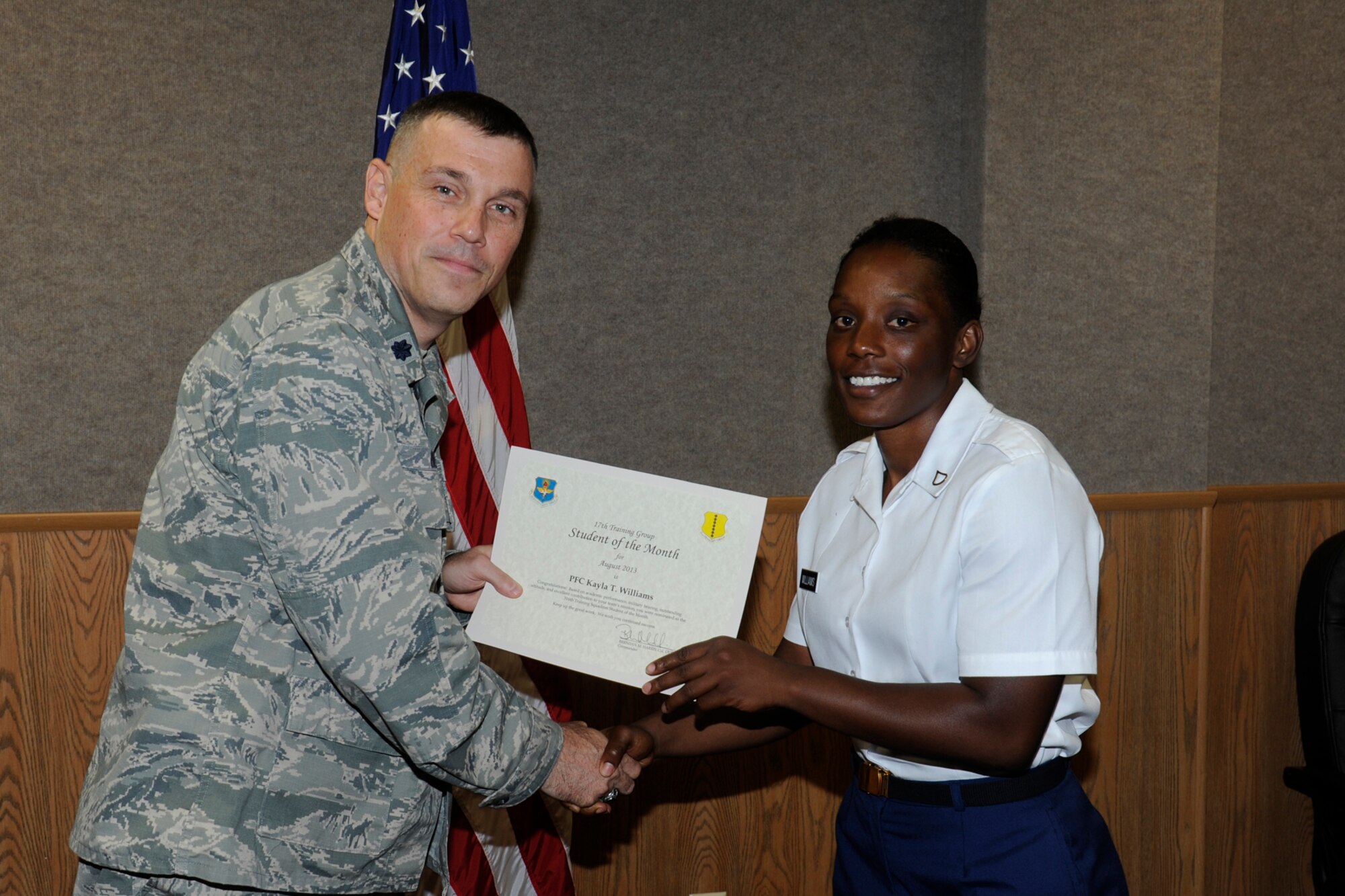 GOODFELLOW AIR FORCE BASE, Texas -- Lt. Col. Edward Blitt, 17th Training Group deputy commander, presents the August 316th Training Squadron Student of the Month award to Army Pfc. Kayla Williams, Sept. 6. (U.S. Air Force photo by Staff Sgt. Austin Knox)