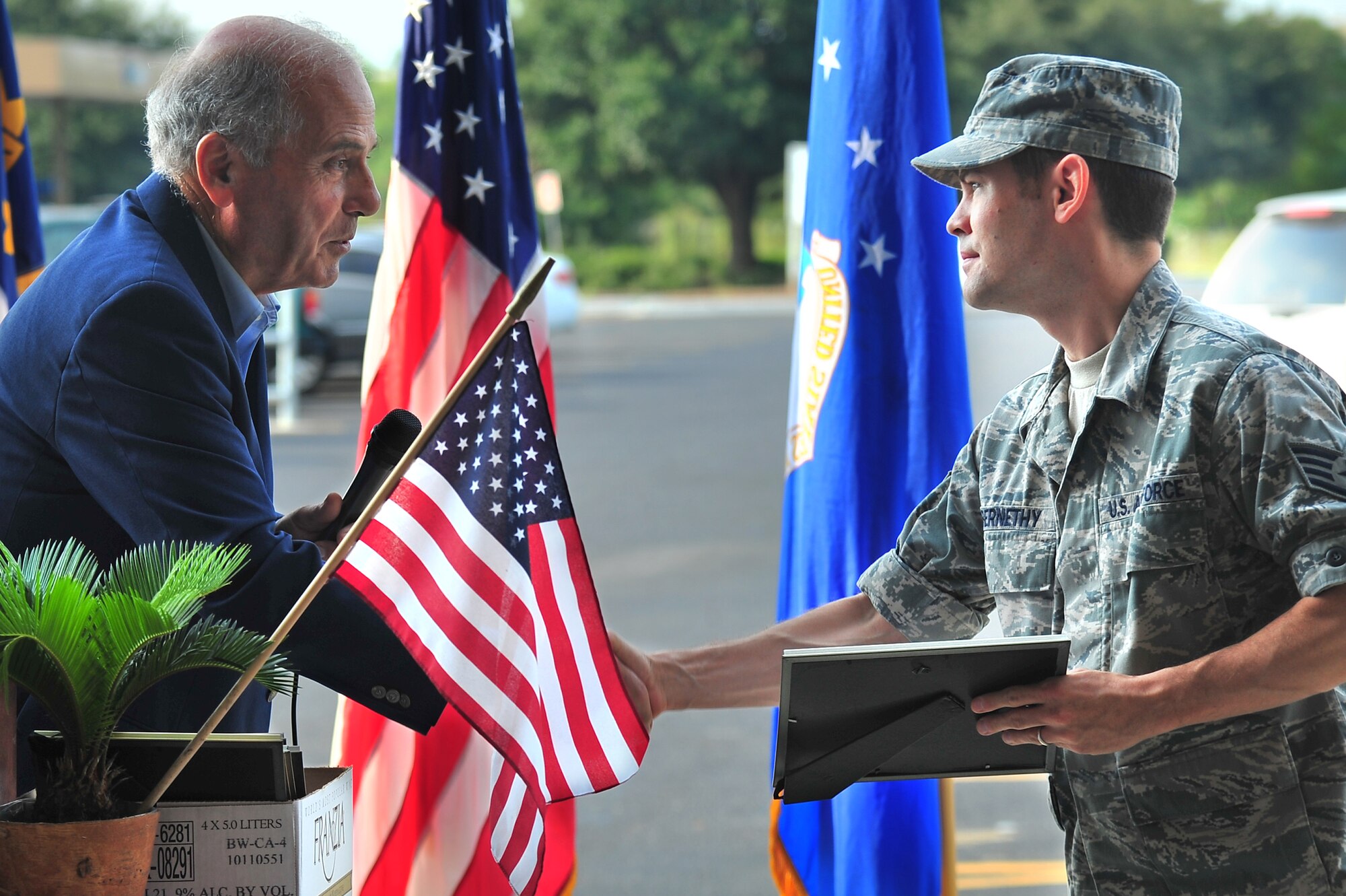 Don Johnstone, Wayne County Chamber of Commerce Military Affairs Committee member, presents a certificate of recognition to U.S. Air Force Staff Sgt. Alan Abernathy, 916th Air Refueling Wing Public Affairs photojournalist, during a 9/11 memorial ceremony in Goldsboro, N.C., Sept. 11, 2013. Team Seymour Airmen and local law enforcement officers were acknowledged for their service to the nation since 9/11. (U.S. Air Force photo by Senior Airman Aubrey White)