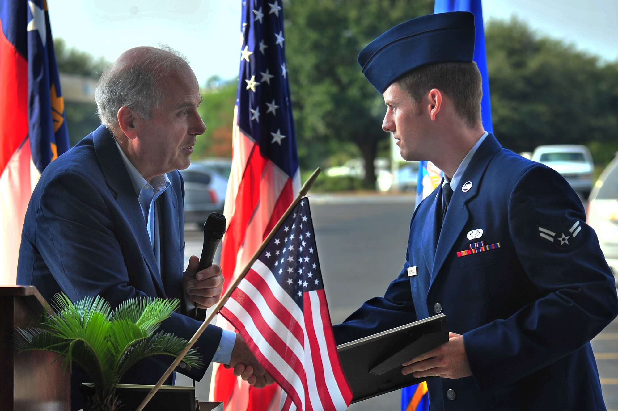 Don Johnstone, Wayne County Chamber of Commerce Military Affairs Committee member, presents a certificate of recognition to U.S. Air Force Airman 1st Class John Ingersoll, 4th Fighter Wing knowledge operations manager, during a 9/11 memorial ceremony in Goldsboro, N.C., Sept. 11, 2013. Several members of Team Seymour and local law enforcement officers were recognized for their service to the nation since 9/11. (U.S. Air Force photo by Senior Airman Aubrey White)
