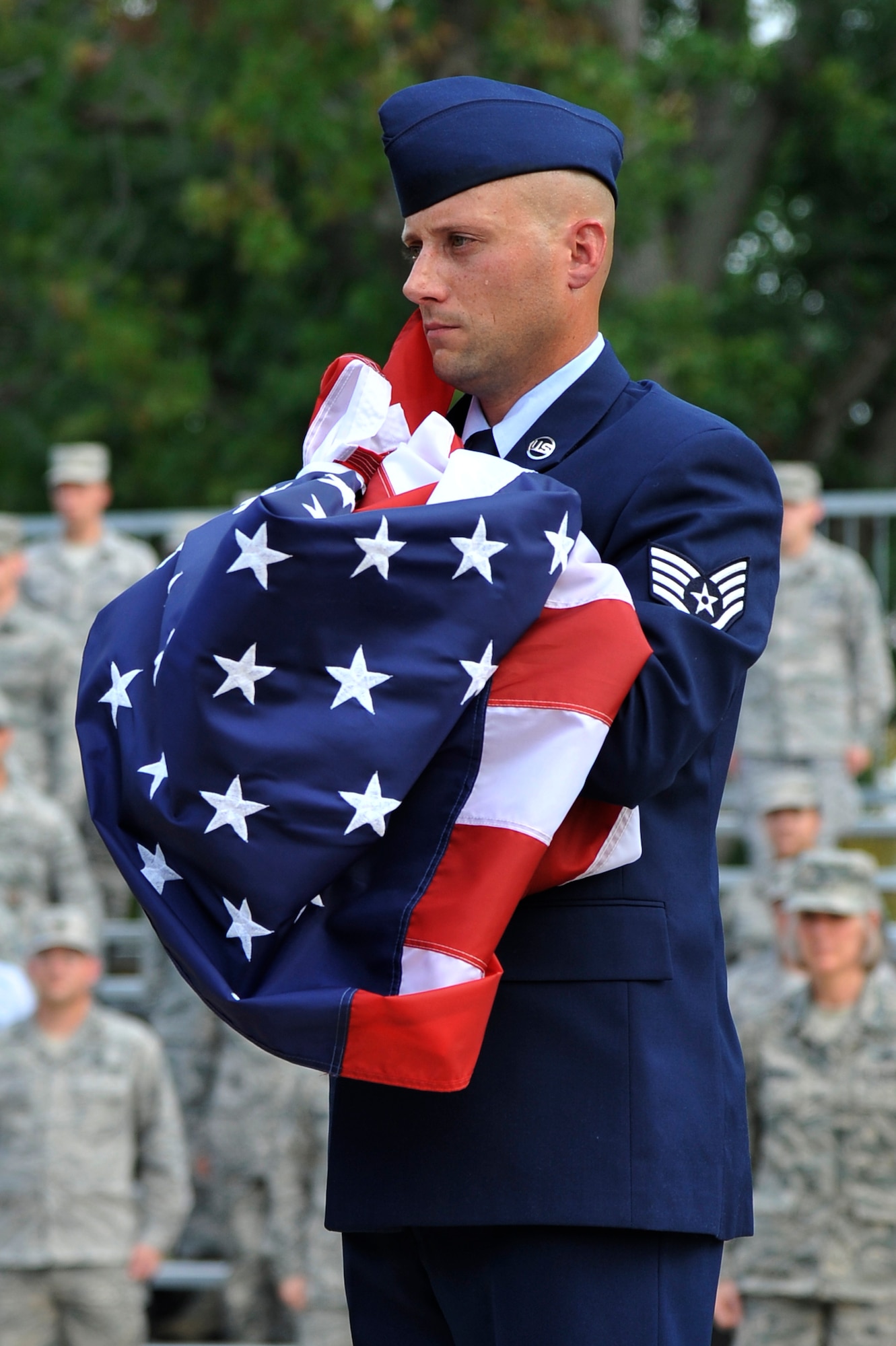 Staff Sgt. Steven Short secures the U.S. flag during a retreat ceremony honoring the victims of the 9/11 terror attacks Sept. 11, 2012, Scott Air Force Base, Ill. The ceremony provided Team Scott a means to reflect on the tragedy that claimed the lives of 2996 people. Short is a fire inspector assigned to the 375 Civil Engineer Squadron. (U.S. Air Force photo/Staff Sgt. Christopher Boitz)