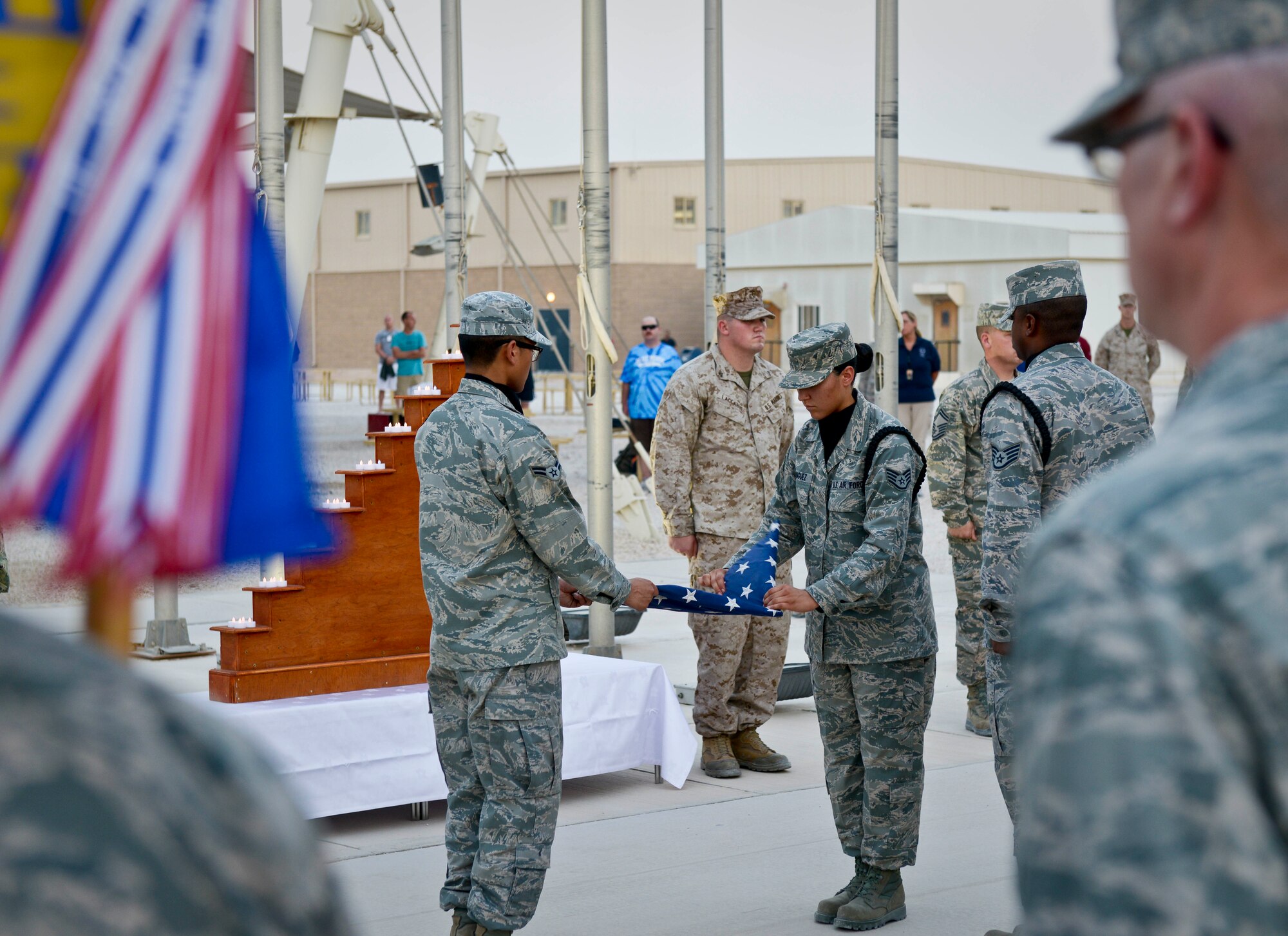 Members of the base honor guard fold the flag during a 9/11 retreat ceremony at the 379th Air Expeditionary Wing in Southwest Asia, Sept. 11, 2013. The ceremony included a special session where fallen Grand Slam warriors were paid tribute for their ultimate sacrifice in the war on terrorism. The 379th AEW has been a constant in the U.S. Air Forces Central Command's area of responsibility over the last nearly 12 years. (U.S. Air Force photo/Staff Sgt. Benjamin W. Stratton)
