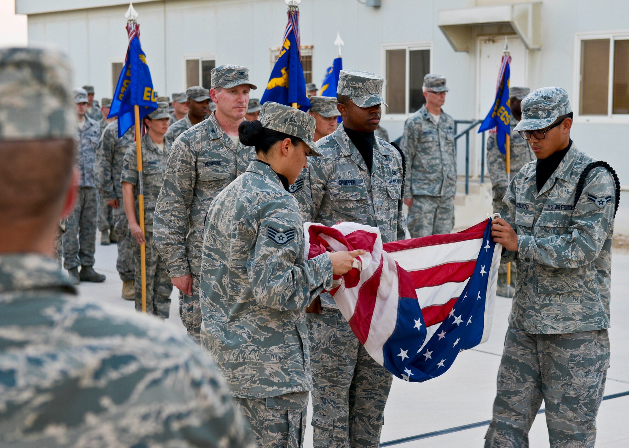 Members of the base honor guard fold the flag during a 9/11 retreat ceremony at the 379th Air Expeditionary Wing in Southwest Asia, Sept. 11, 2013. The ceremony included a special session where fallen Grand Slam warriors were paid tribute for their ultimate sacrifice in the war on terrorism. The 379th AEW has been a constant in the U.S. Air Forces Central Command's area of responsibility over the last nearly 12 years. (U.S. Air Force photo/Staff Sgt. Benjamin W. Stratton)