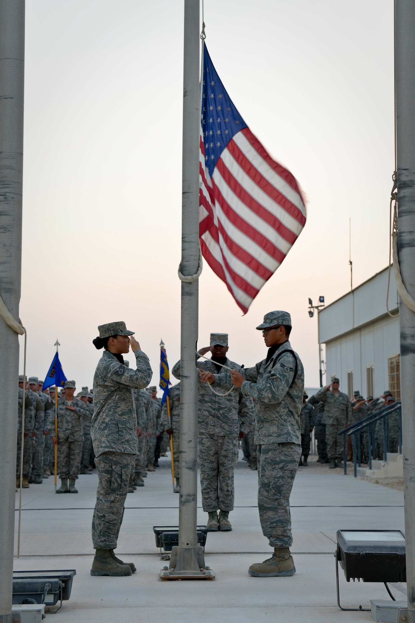 Members of the base honor guard lower the flag while retreat is played during a 9/11 retreat ceremony at the 379th Air Expeditionary Wing in Southwest Asia, Sept. 11, 2013. The 379th AEW has been a constant in the U.S. Air Forces Central Command's area of responsibility over the last nearly 12 years. (U.S. Air Force photo/Staff Sgt. Benjamin W. Stratton)