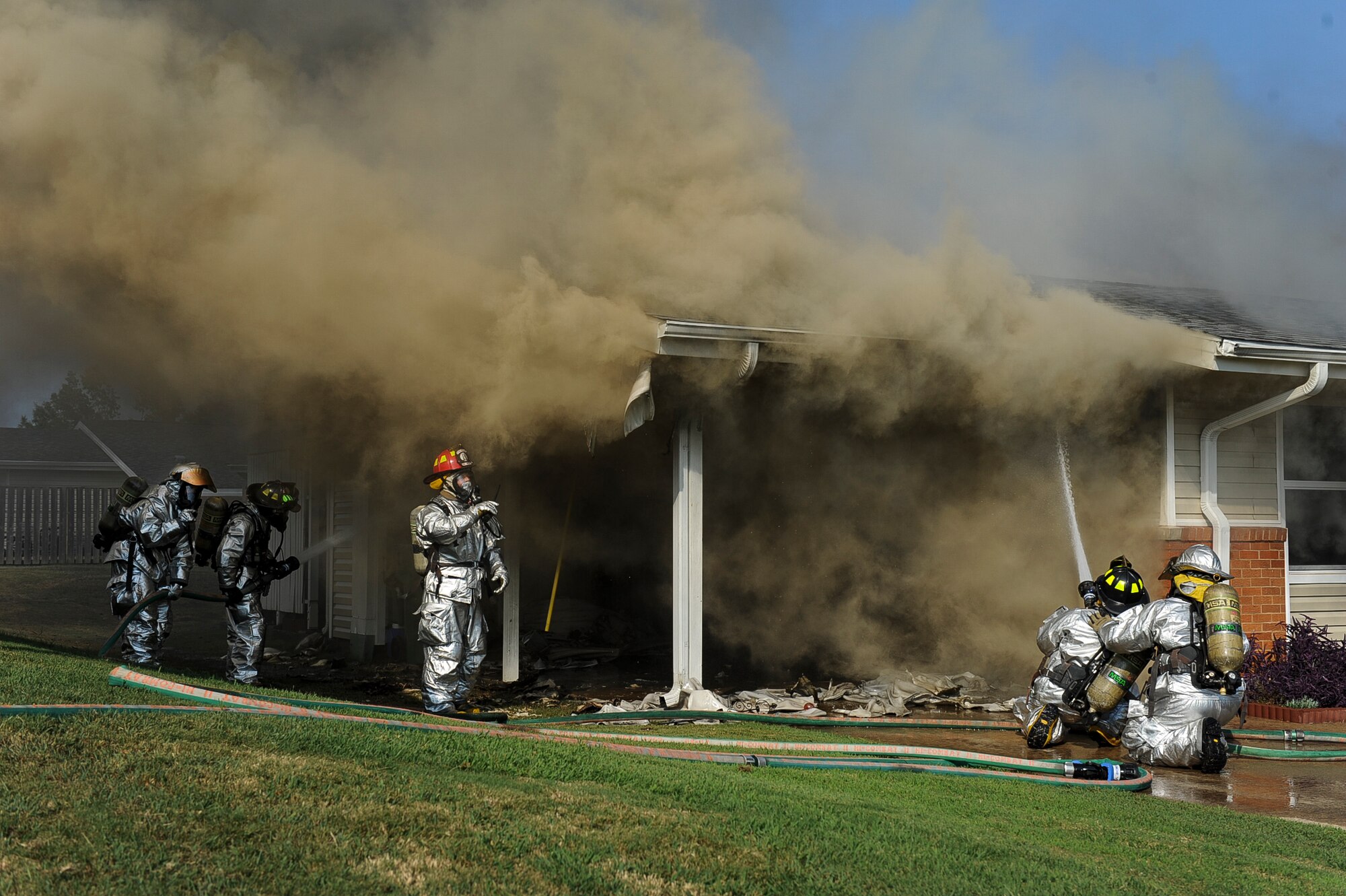 Members of the 19th Civil Engineer Squadron perform firefighting suppression techniques during a house fire Sept. 7, 2013, at Little Rock Air Force Base, Ark. The members of the 19th CES respond to approximately 800 calls a year. (U.S. Air Force photo by Airman 1st Class Cliffton Dolezal)