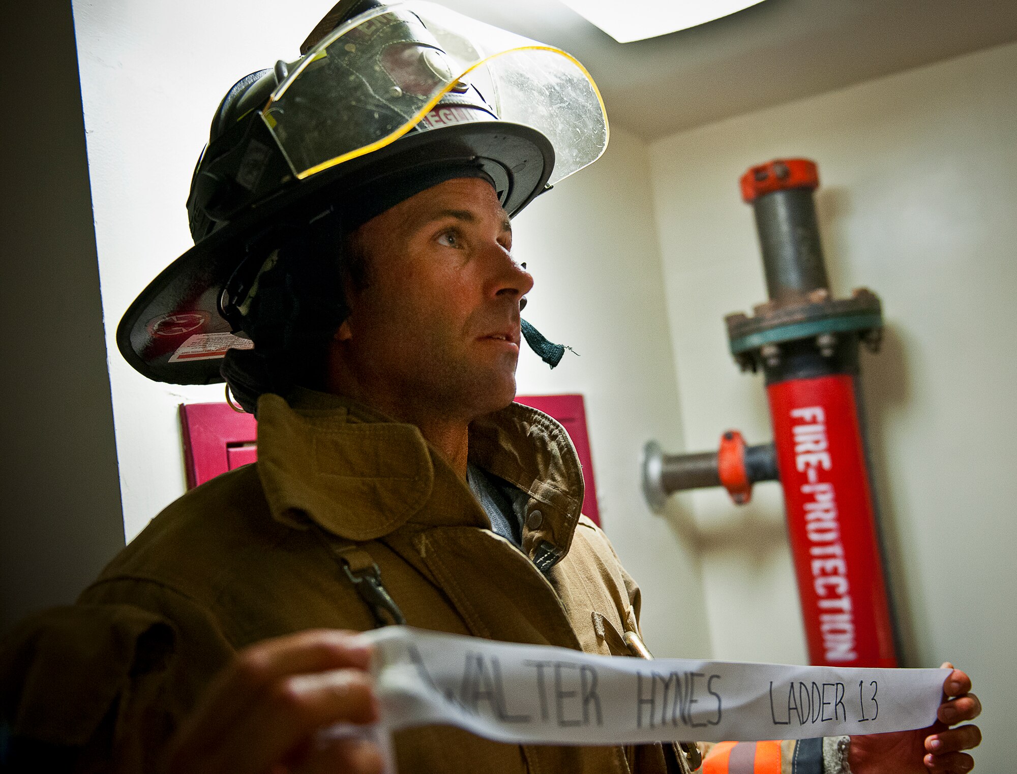 An Eglin Air Force Base firefighter presents a ribbon with a name of the 343 firefighters killed Sept. 11, 2001 after ascending to the top 11-story air traffic control tower Sept. 11. When each name was delivered to the top of the tower it was read aloud.  The event ended on top of the tower with participants hanging the ribbons over the balcony on either side of an American Flag. (U.S. Air Force photo/Samuel King Jr.)