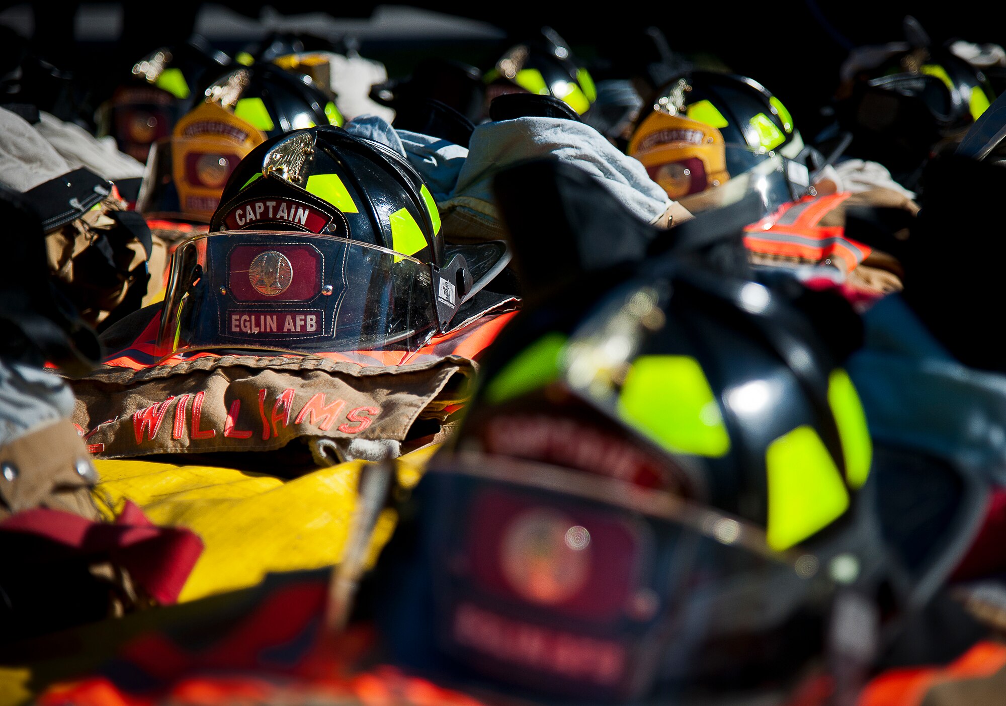 Helmets and gear of the Eglin Air Force Base fire department are aligned in rows prior to their mission Sept. 11.  Fire department Airmen and civilians ascended the 11-story air traffic control tower carrying ribbons with the names of the 343 firefighters killed Sept. 11, 2001. When each name was delivered to the top of the tower it was read aloud.  The event ended on top of the tower with participants hanging the ribbons over the balcony on either side of an American Flag. (U.S. Air Force photo/Samuel King Jr.)