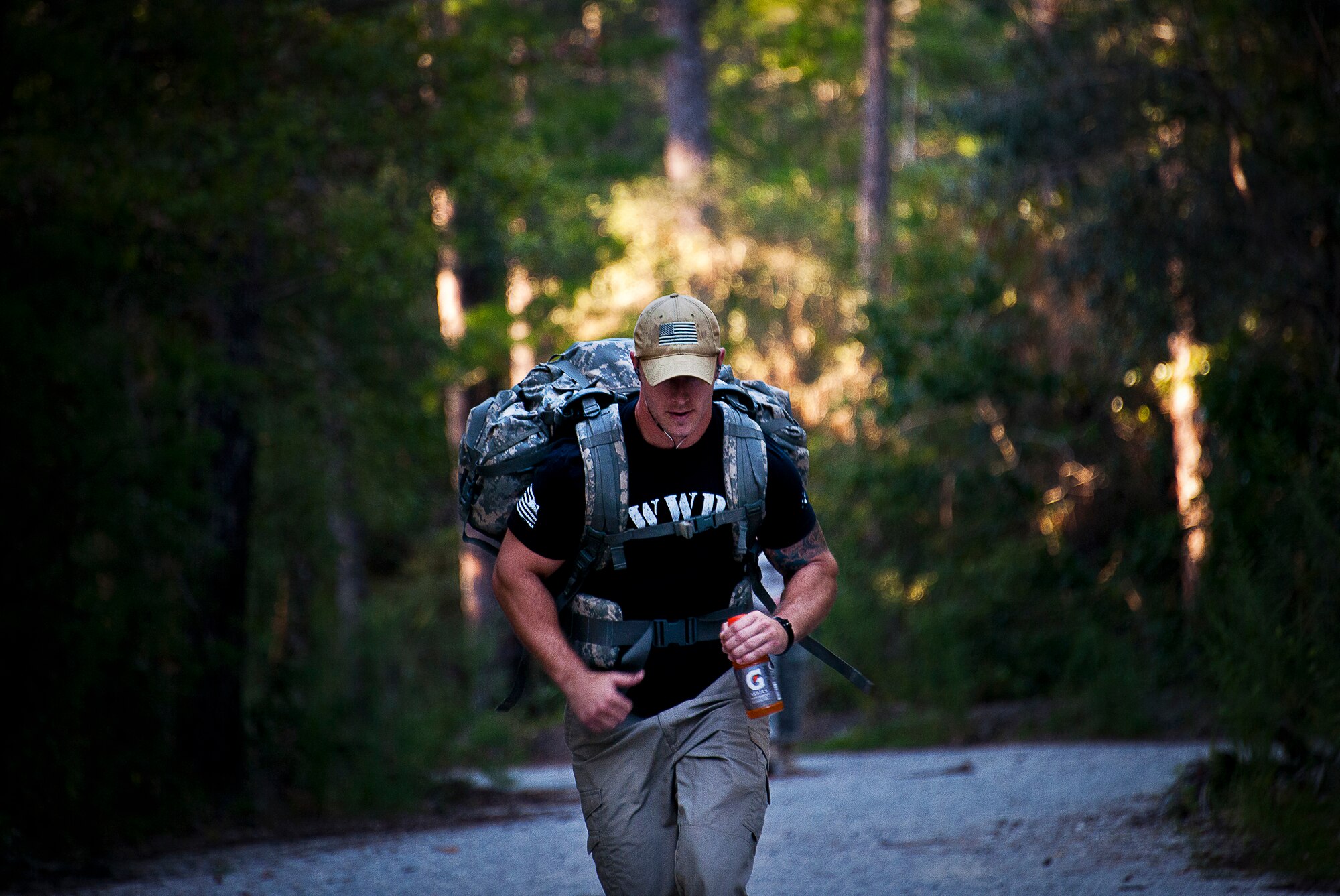 A military member hustles through a wooded area during the Fallen Defender Ruck March Sept. 11 at Eglin Air Force Base, Fla.  More than 200 military members and civilians came out to walk or run the 4-mile trail and pay respect to fallen security forces Airmen along the way.  (U.S. Air Force photo/Samuel King Jr.)