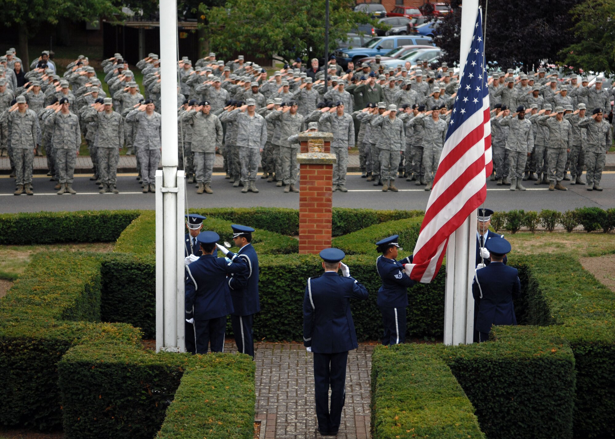Team Mildenhall members salute the U.S. flag as it’s lowered during a retreat ceremony Sept. 11, 2013, on RAF Mildenhall, England. Retreat is a long-standing tradition honoring the flag and signaling the end of the duty day. Retreat typically takes place on the last Friday of every month, but RAF Mildenhall held a ceremonial retreat in honor of those who died in the 9/11 attacks. (U.S. Air Force photo by Airman 1st Class Dillon Johnston/Released)