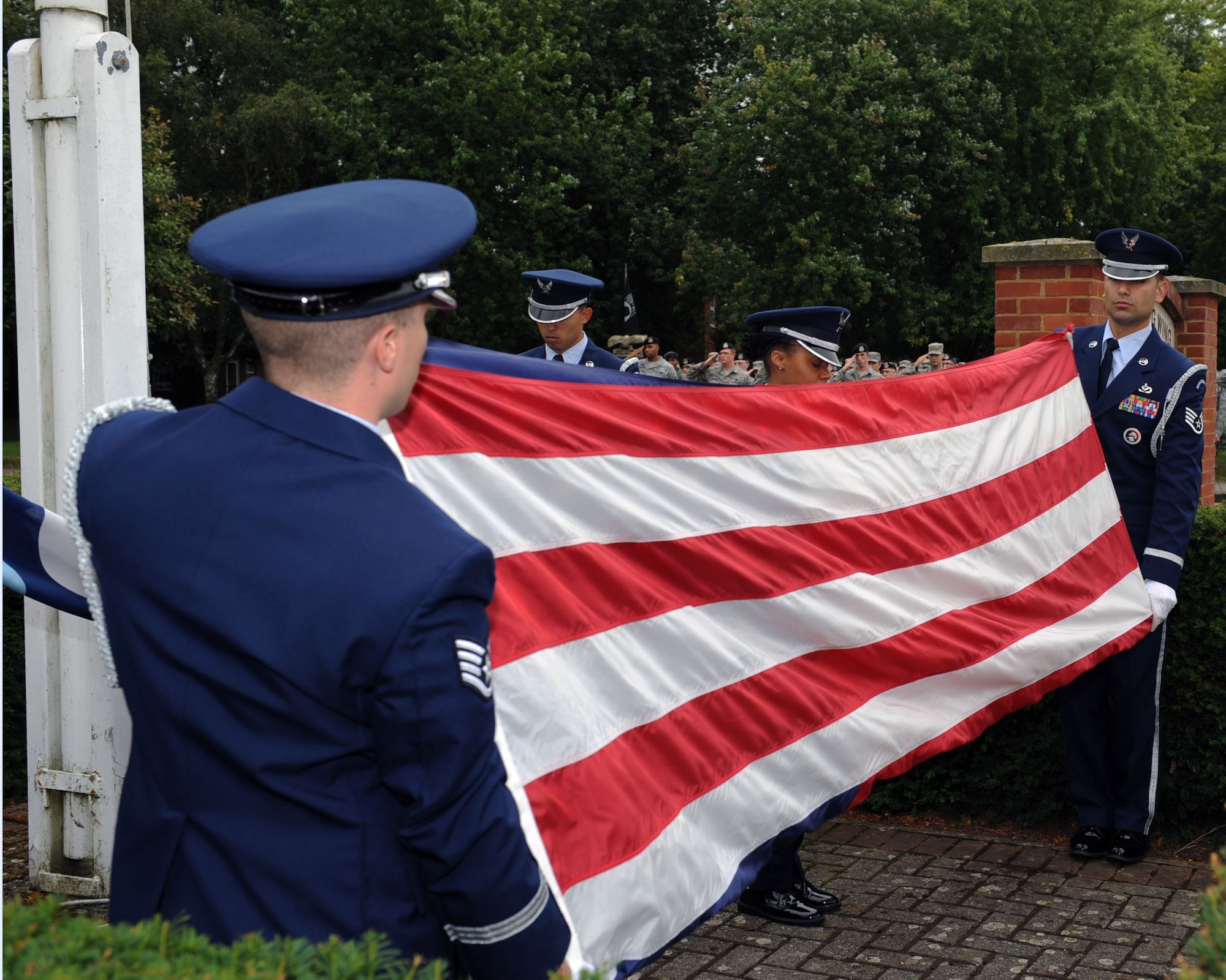 Members of the Team Mildenhall Honor Guard fold the U.S. flag during a retreat ceremony Sept. 11, 2013, on RAF Mildenhall, England. Retreat is a long-standing tradition honoring the flag and signaling the end of the duty day. Retreat typically takes place on the last Friday of every month, but RAF Mildenhall held a ceremonial retreat in honor of those who died in the 9/11 attacks. (U.S. Air Force photo by Airman 1st Class Preston Webb/Released)
