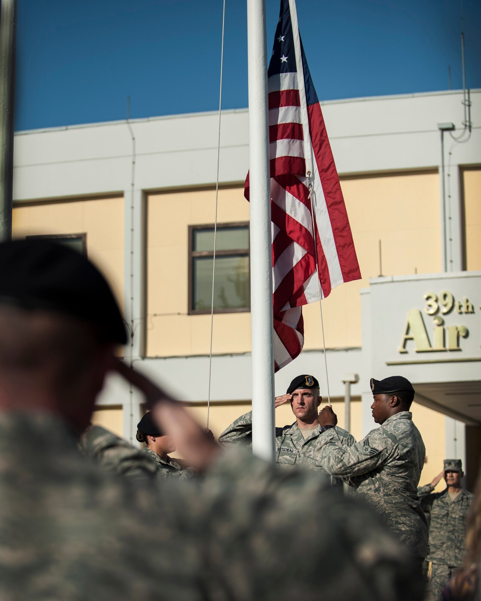 Airmen salute as the American flag is lowered during the 9/11 Retreat Ceremony Sept. 11, 2013, at Incirlik Air Base, Turkey. Airmen from the 39th Security Forces Squadron were chosen to lower the flag to represent the first responders that lost their lives on 9/11. (U.S. Air Force photo by Airman 1st Class Nicole Sikorski/Released)