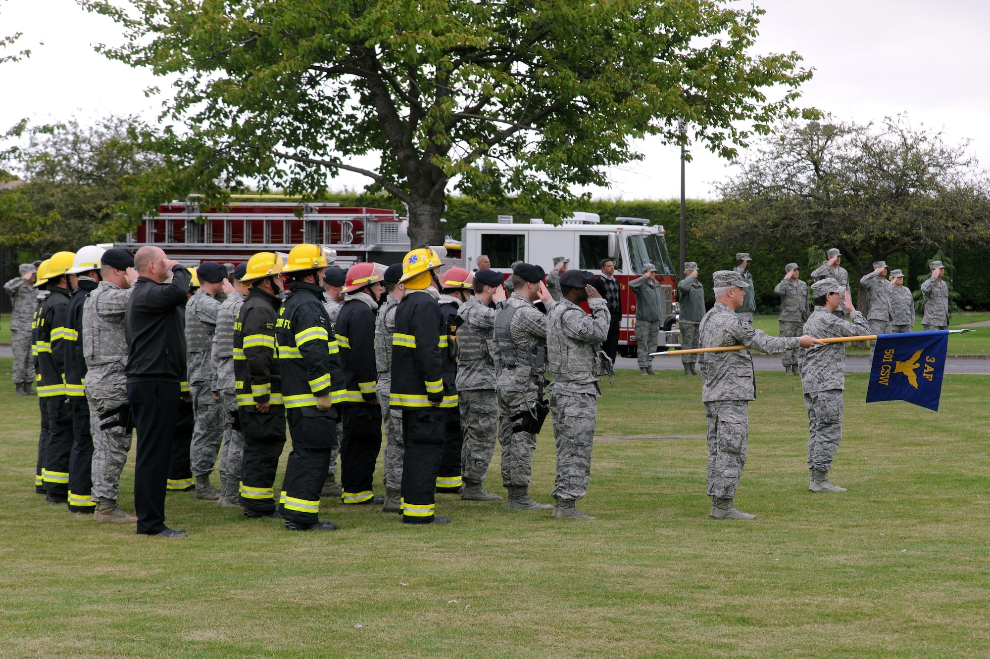 RAF ALCONBURY, United Kingdom – A formation consisting of members of 423rd Security Forces Squadron and 423rd Civil Engineer Squadron fire protection flight salute and stand at attention during the playing of the U.S. and British national anthems Sept. 11 during a retreat held in memory of the 9/11 attacks. The day marked the twelfth anniversary of the attacks. (U.S. Air Force photo by Staff Sgt. Brian Stives)