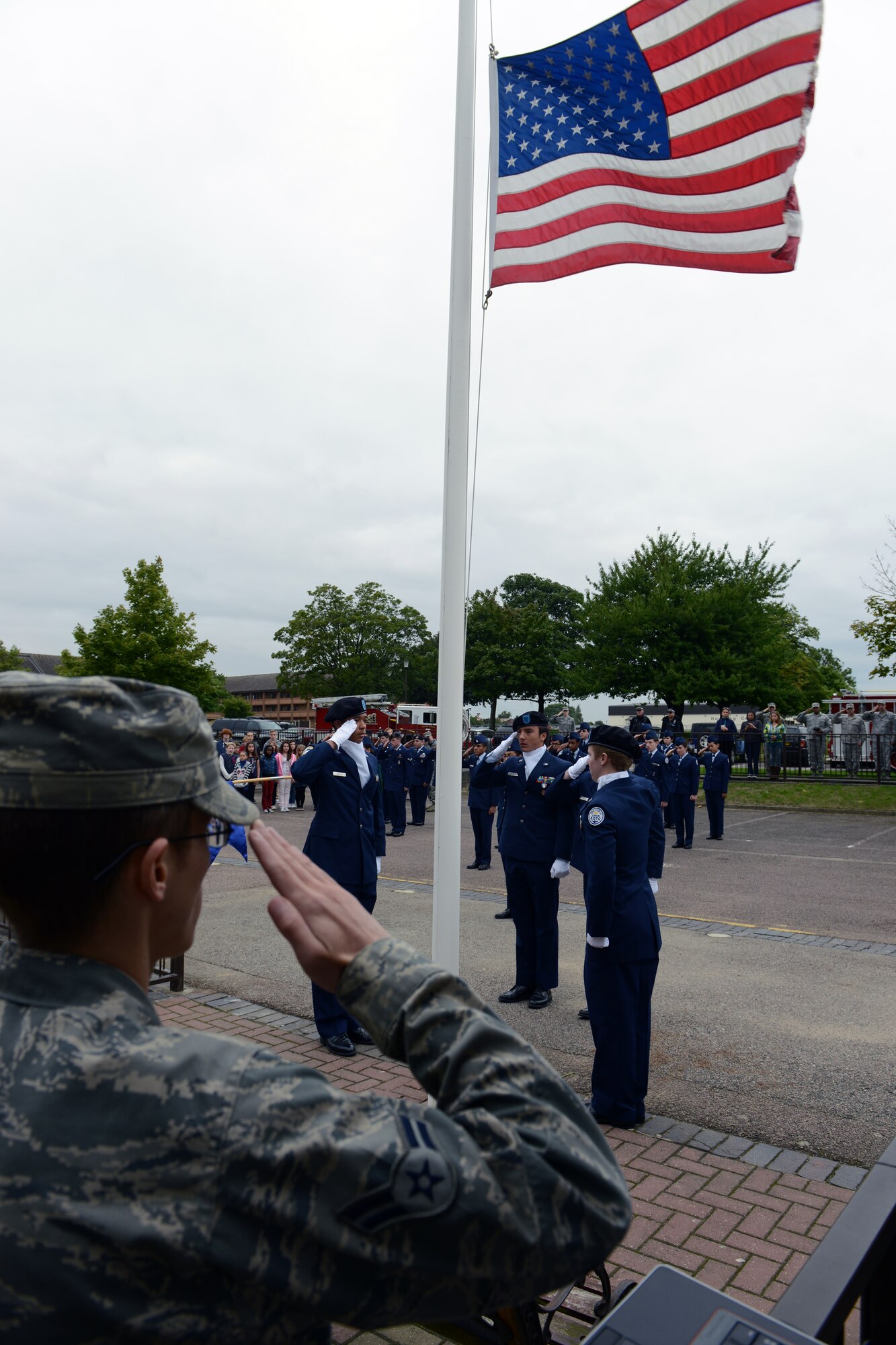 RAF ALCONBURY, United Kingdom – Members of the 501st Combat Support Wing and Alconbury Air Force Junior Reserve Officers' Training Corps salute during the playing of the U.S. National Anthem during a 9/11 Remembrance Ceremony at the Alconbury Middle/High School Sept. 11. The day marked the twelfth anniversary of the attacks. (U.S. Air Force photo by Tech. Sgt. Chrissy Best)