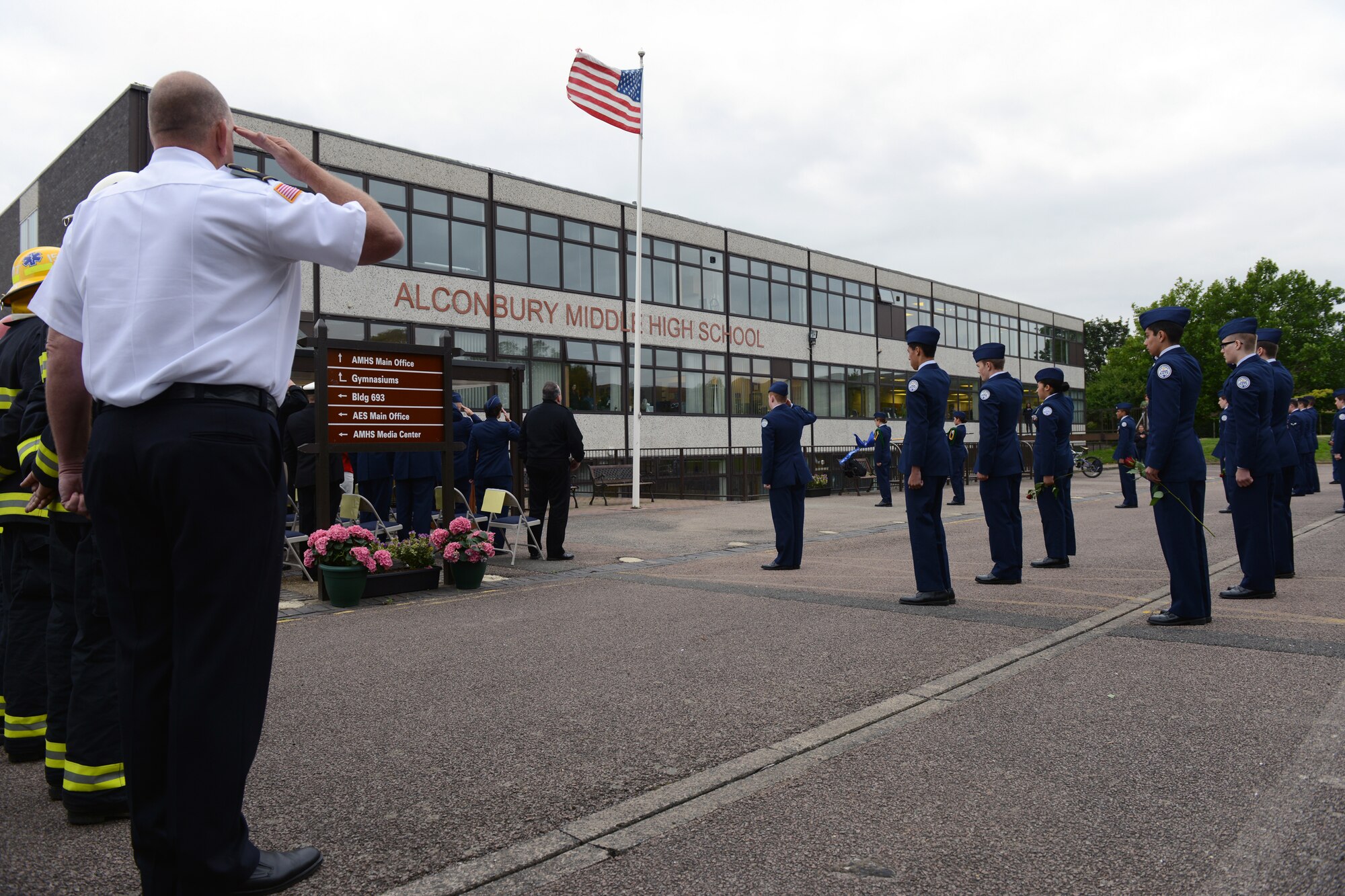 RAF ALCONBURY, United Kingdom – Members of the 423rd Civil Engineer Squadron fire protection flight and Alconbury Air Force Junior Reserve Officers' Training Corps salute during the playing of the U.S. National Anthem during a 9/11 Remembrance Ceremony at the Alconbury Middle/High School Sept. 11. The day marked the twelfth anniversary of the attacks. (U.S. Air Force photo by Tech. Sgt. Chrissy Best)