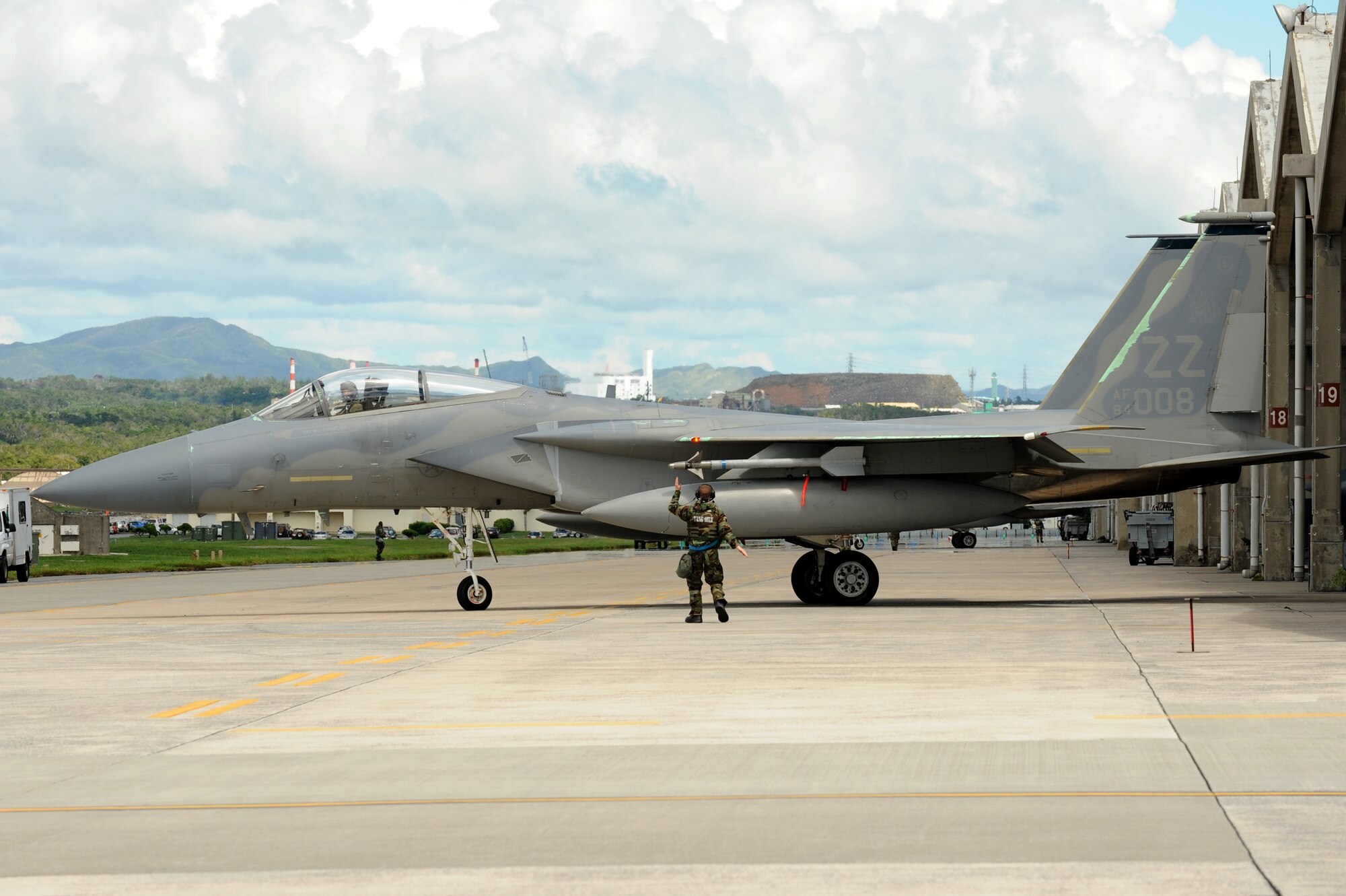 A U.S. Air Force member marshals an F-15 Eagle onto the runway during a local operational readiness exercise on Kadena Air Base, Japan, Sept. 12, 2013. The 18th Wing periodically conducts LOREs to maintain proficiency in their capabilities to support the common defense of the Asia-Pacific region. (U.S. Air Force photo by Airman 1st Class Hailey R. Davis)