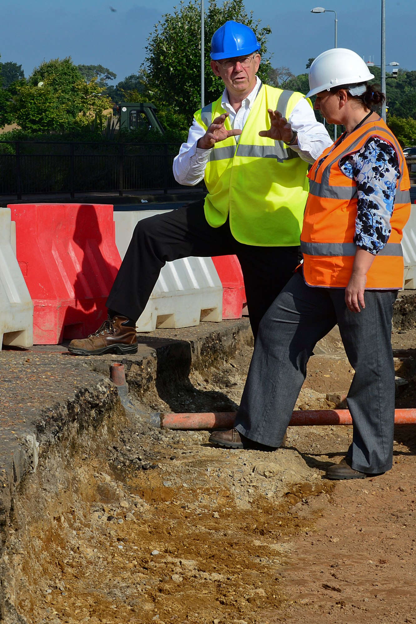 Brian Garrad, Defense Infrastructure Organization project manager, and Vicky Stayton, 48th Civil Engineer Squadron engineering construction project manager, discuss safety objectives while at the construction site on Lords Walk Road on Royal Air Force Lakenheath, England, Aug. 29, 2013. Base agencies have put together an Area Development Plan to increase safety and improve the quality of life for base residents. The projects include installing walkways between the housing and community areas and adding denial barriers, higher curbing and other force protection measures around Gate 2. (U.S Air Force photo by Airman 1st Class Dana J. Butler/Released)