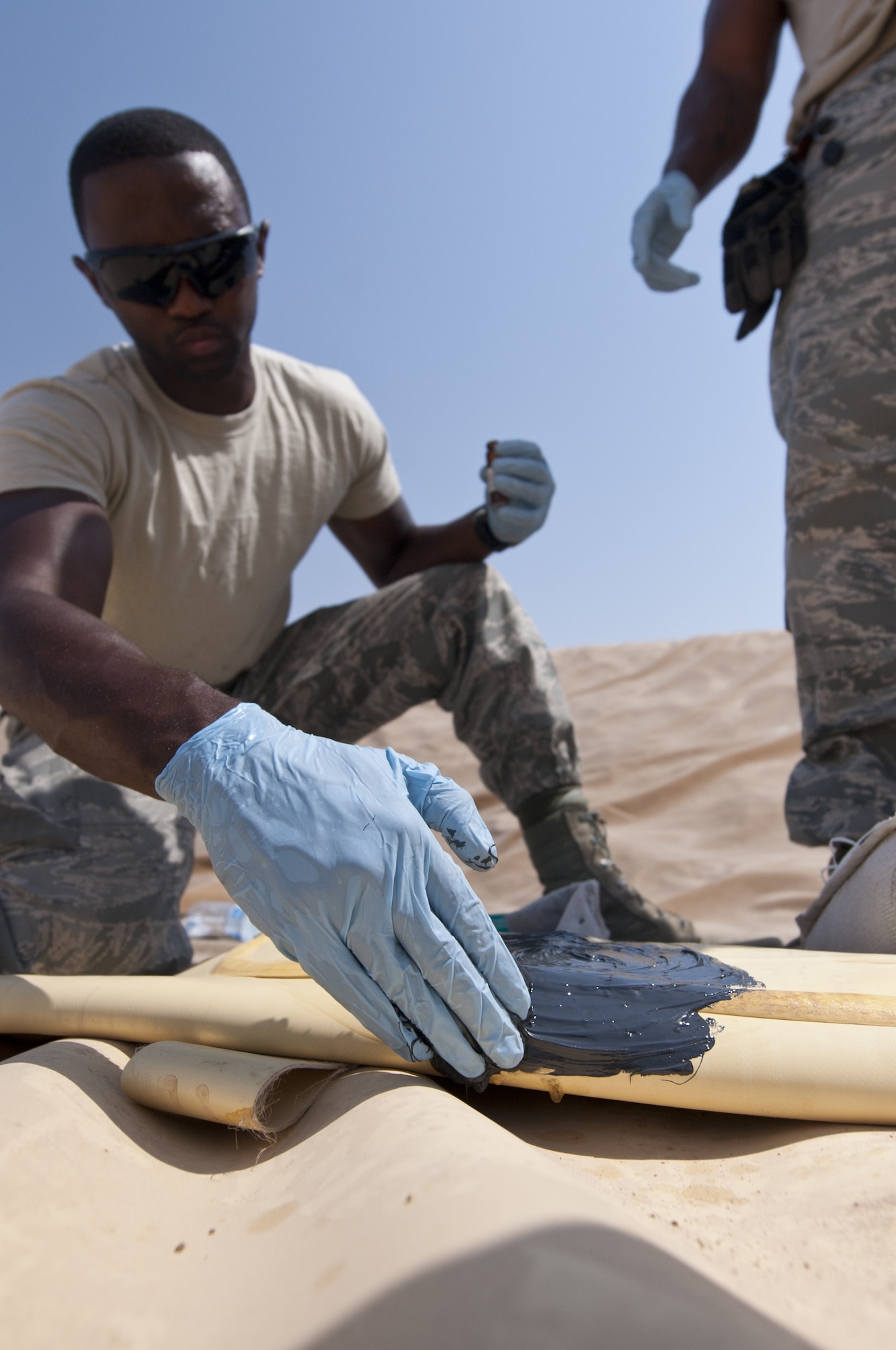 U.S. Air Force Airman 1st Class Alec Emerson, 380th Expeditionary Logistics Readiness Squadron fuels storage journeyman, uses a product designed to patch holes in fuel bladders at an undisclosed location in Southwest Asia Sept. 3, 2013. If a fuel bladder has a leak, the fuels storage team is responsible for repairing it. The fuels storage team is responsible for patching these holes. Emerson calls Hampton, Va., home and is deployed from Yokota Air Base, Japan. (U.S. Air Force photo by Staff Sgt. Jacob Morgan)