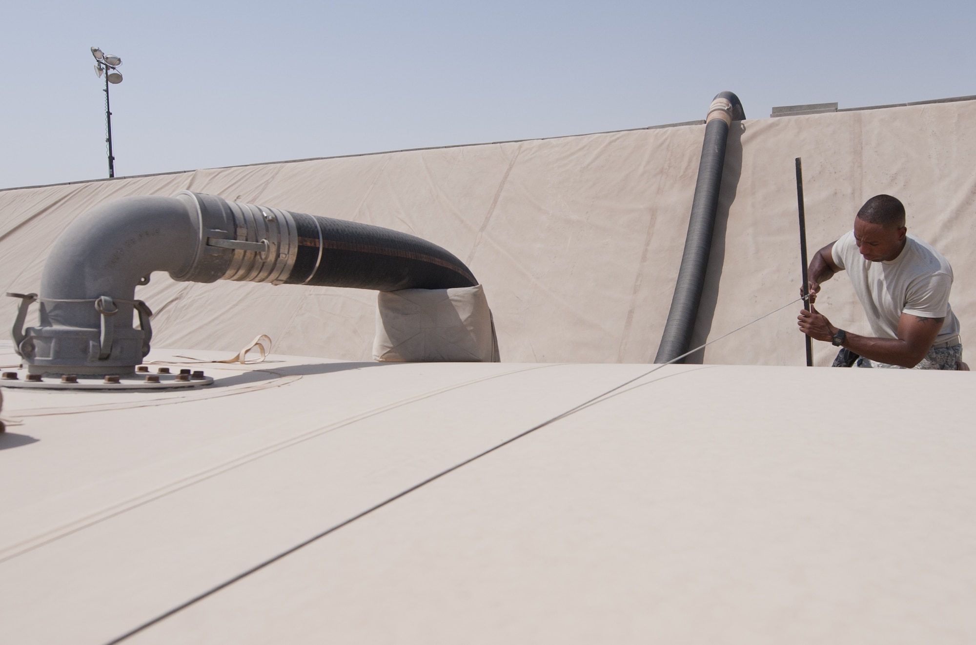 U.S. Air Force Staff Sgt. Joseph Lima, 380th Expeditionary Logistics Readiness Squadron fuels bulk storage supervisor, measures the height of the bladder indicating how much fuel is in it at an undisclosed location in Southwest Asia Sept. 3, 2013. As the supervisor, or ‘Yard Boss’, Lima is responsible for making sure the largest contingency fuel storage area in the Air Force is running properly. Lima calls Bridgeport, Conn., home and is deployed from Minot Air Force Base, N.D. (U.S. Air Force photo by Staff Sgt. Jacob Morgan) 