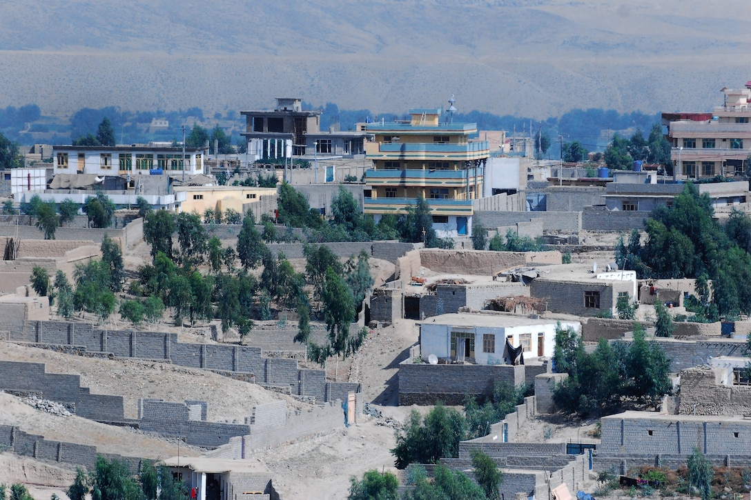 The side door window of a UH-60 Black Hawk helicopter shows a view of Mehtar Lam city in Laghman province, Afghanistan, Sept. 10, 2013, during a personnel movement mission.