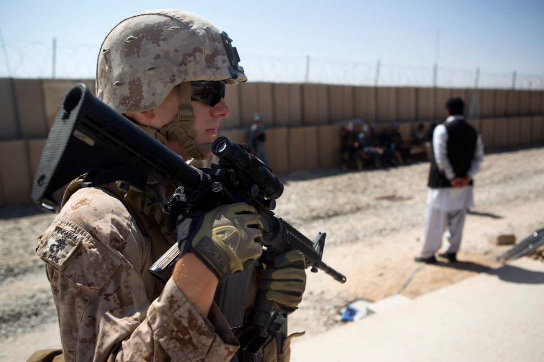 U.S. Marine Corps Sgt. Curtis Dewyea provides security during a ribbon ...