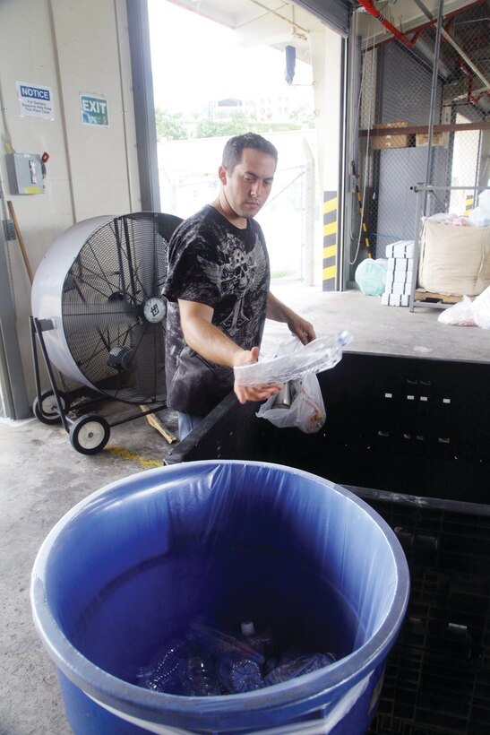 Yoa Espinosa sorts recyclables at the Recycling Center on Camp Foster. Espinosa is one of 20 dedicated employees at the Recycling Center who sort through all the recyclables from the Marine installations on Okinawa. Unlike the cans that are separated by an industrial-sized sorter, the workers must sort plastics by hand. Espinosa is the materials handler with the Recycling Center, Environmental Affairs Branch, Marine Corps Base Camp Smedley D. Butler, Marine Corps Installations Pacific.