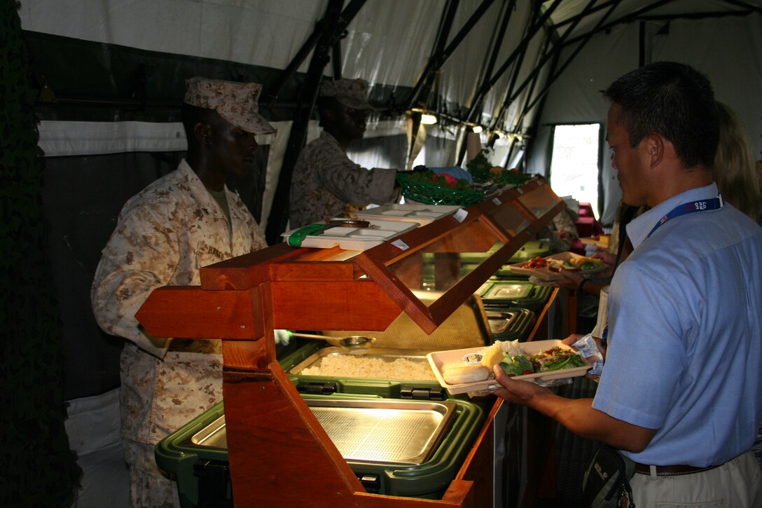 Lance Corporals Nyeme M. Baker, left, and Anthony R. Brown serve food Aug. 21 at Camp Kinser during exercise Ulichi Freedom Guardian 2013. The field mess was set up in conjunction with the exercise to compete for Major General W.P.T. Hill award. Baker is a metal worker with Combat Logistics Battalion 351, Combat Logistics Regiment 35, 3rd Marine Logistics Group, III Marine Expeditionary Force. Brown is a motor transport operator with CLB-351, CLR-35, 3rd MLG, III MEF. 