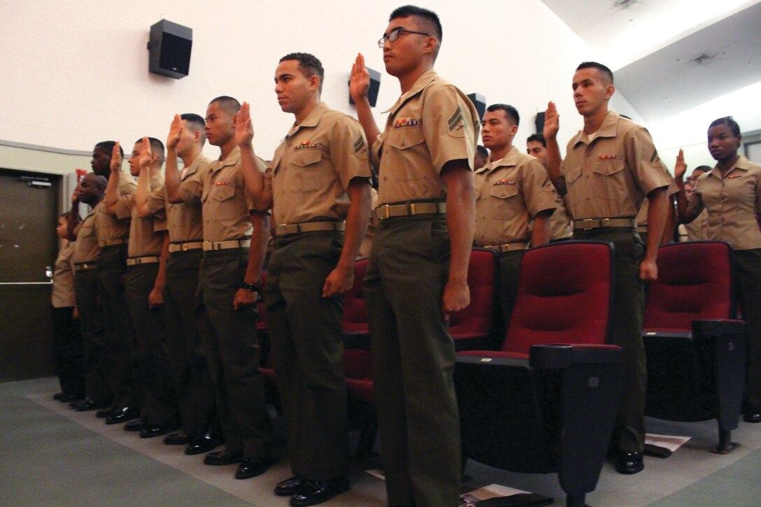 Service members take the oath of citizenship during a ceremony Sept. 6 at the theater on Camp Foster. The service members are with units stationed across Okinawa. 